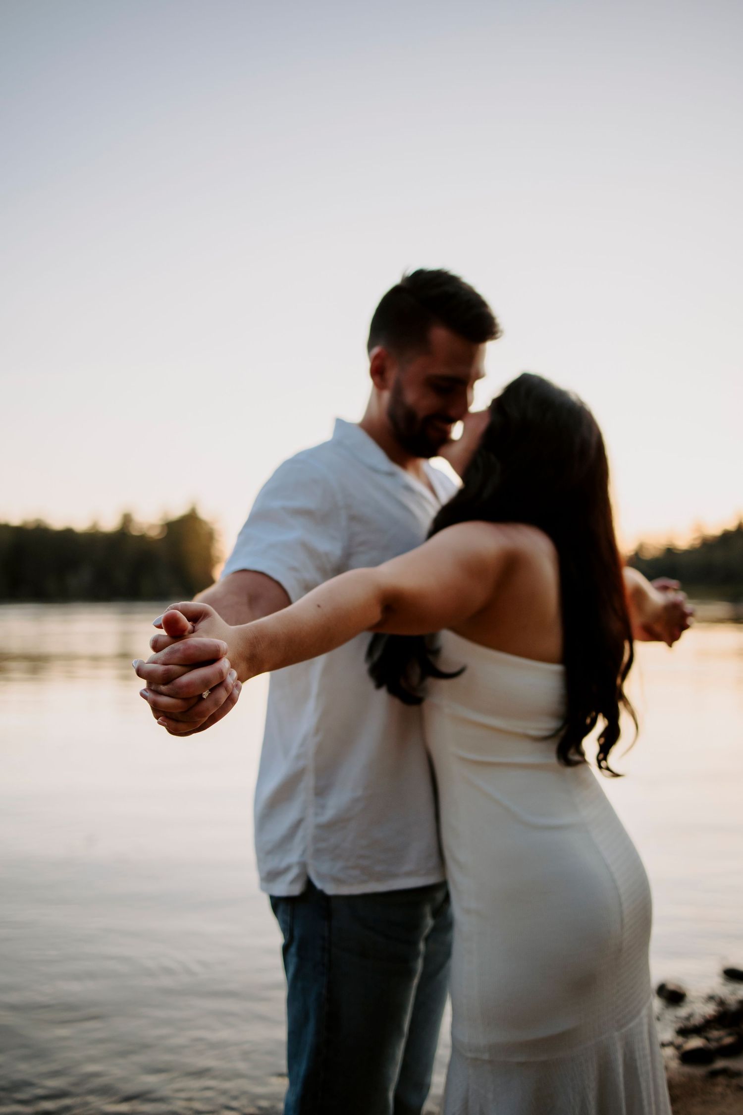 A dancing couple silhouetted against a lakeside sunset.