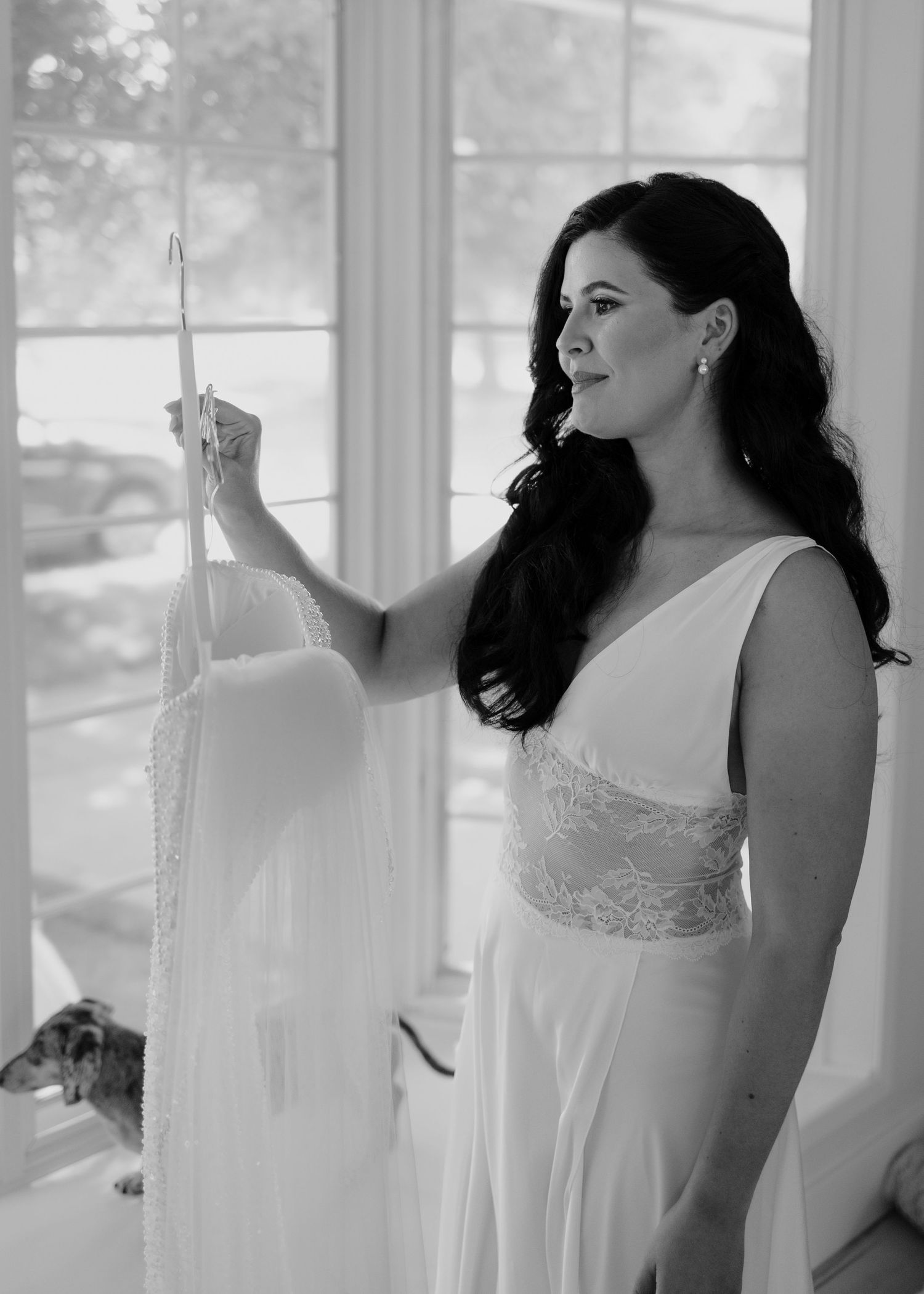 Elegant bridal preparations by sunlit windows in a bright white room.