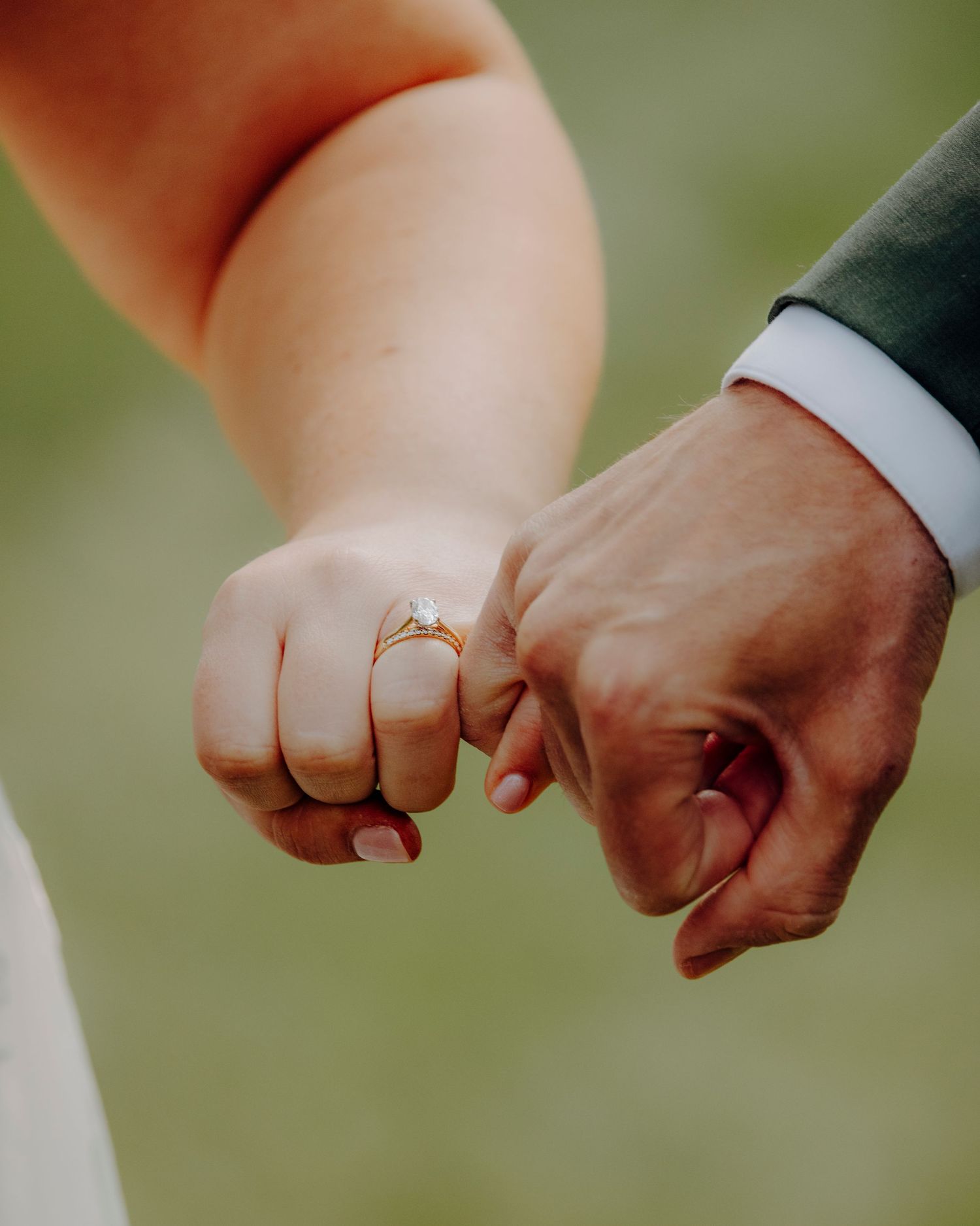 Close-up sequence of hands with wedding rings coming together in a fist bump gesture.