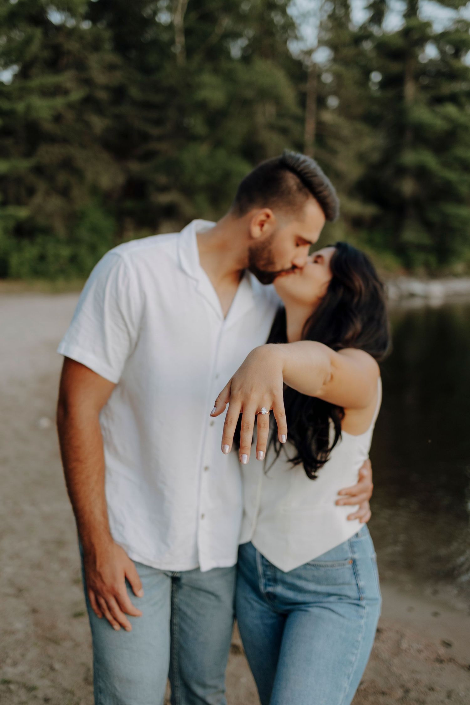 Casual couple in coordinating white tops and jeans share intimate moments outdoors.