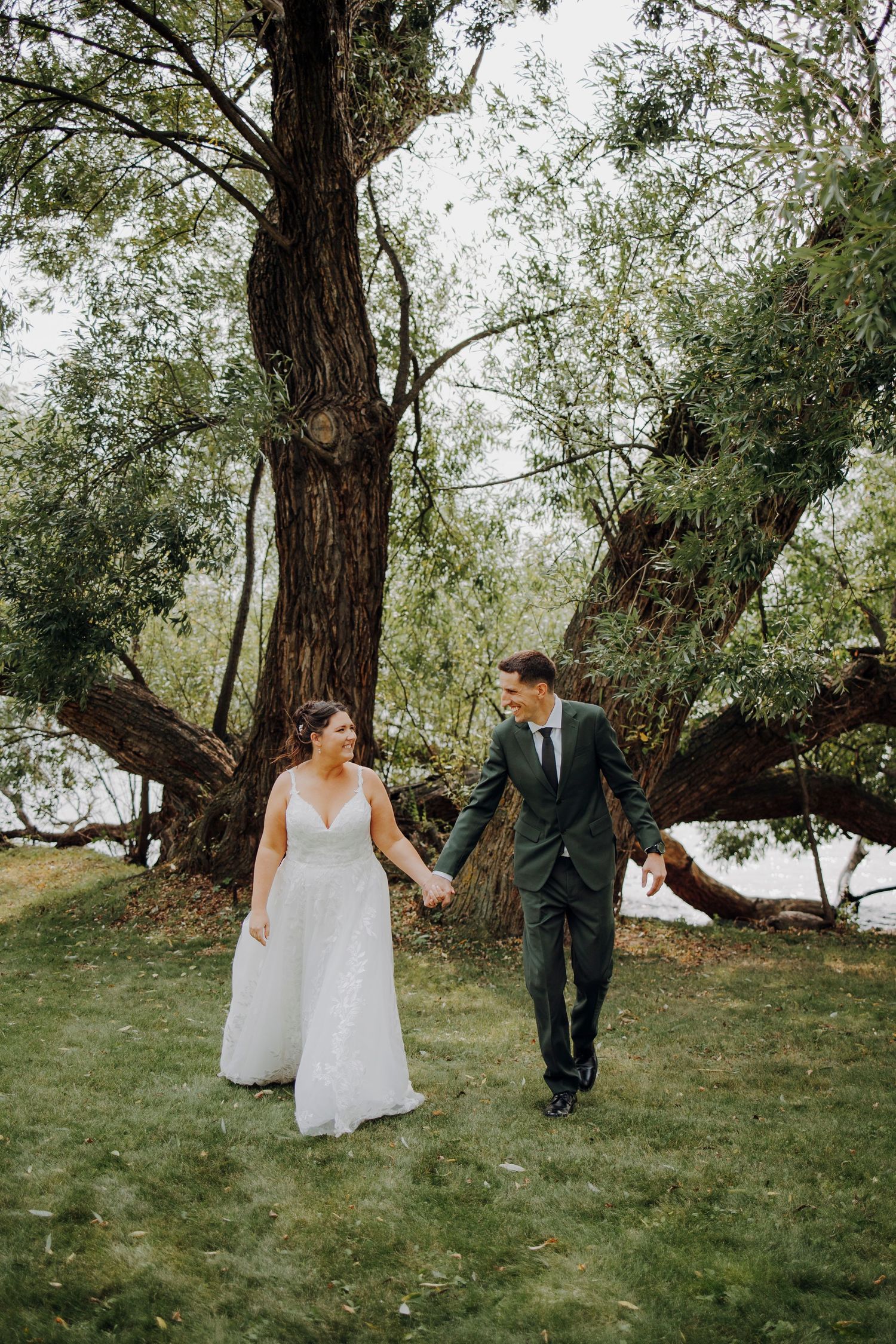 Couple walking hand in hand through scenic outdoor garden setting.