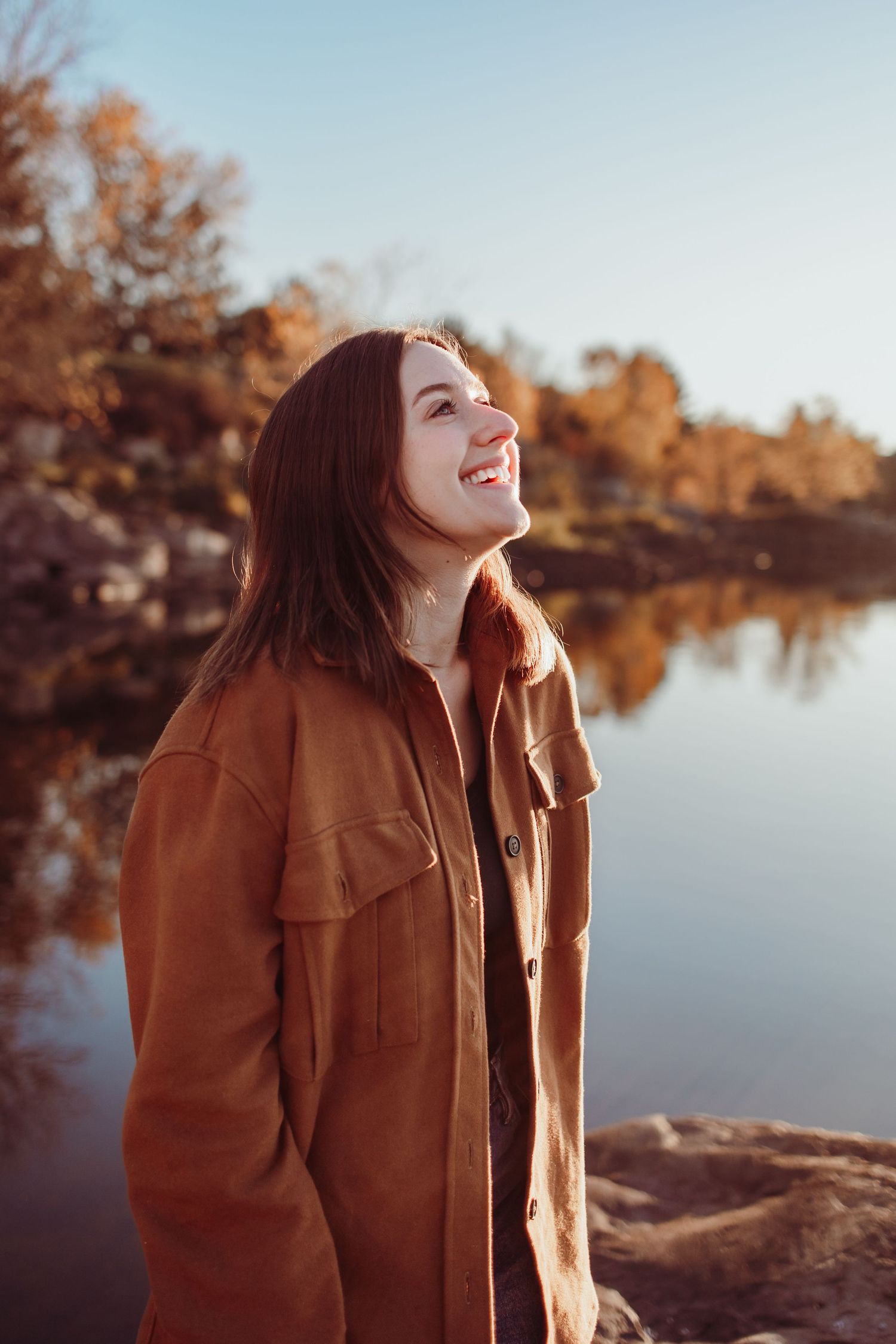 Candid shots of someone in autumn clothing enjoying a peaceful moment by a reflective lake.