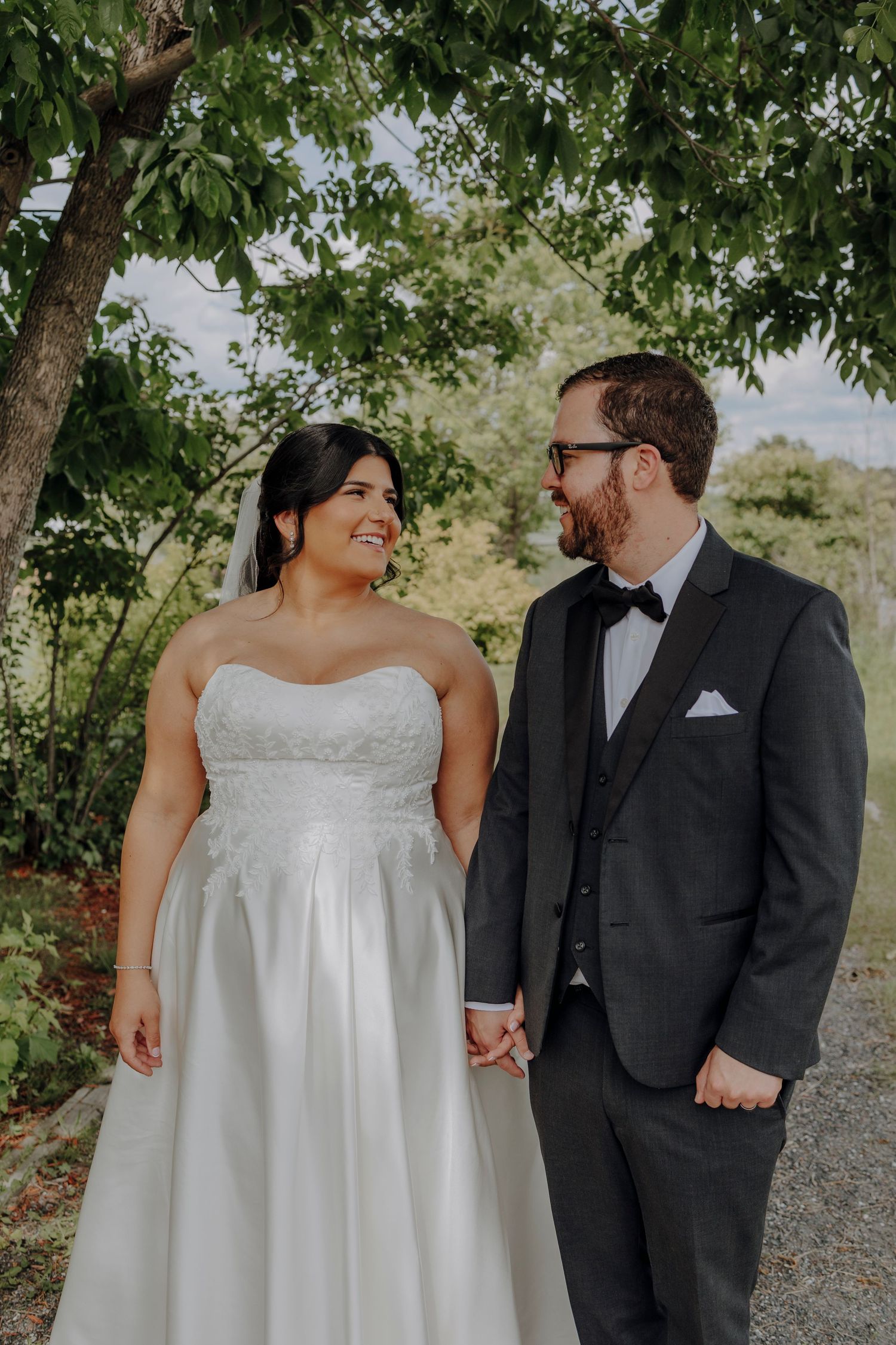 Intimate wedding portraits captured on a gravel path with overhanging trees.
