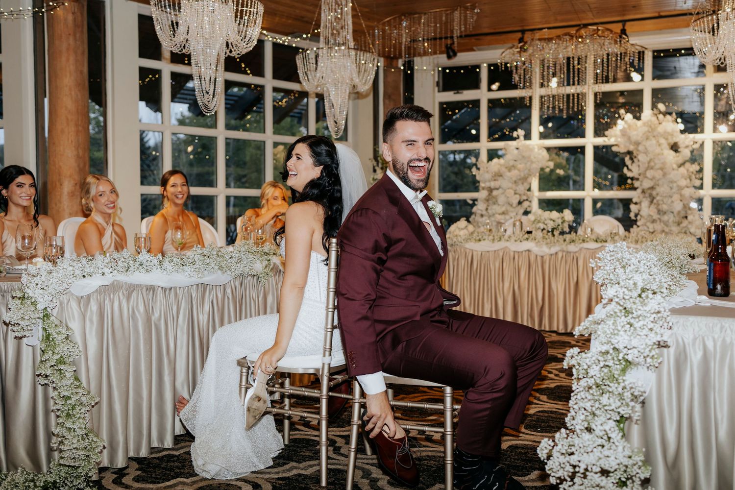 Wedding reception venue decorated with white draping and elegant lighting.