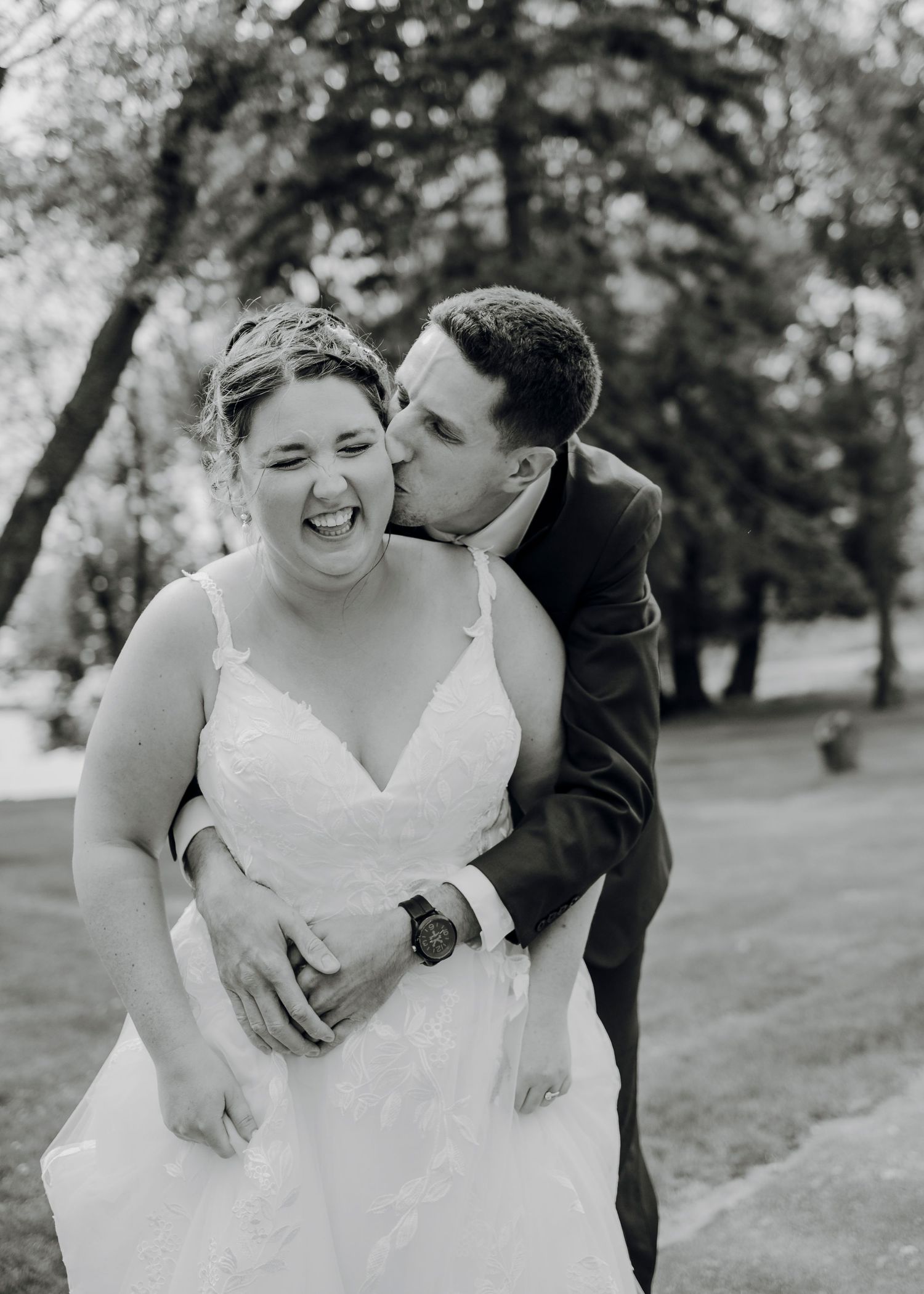 A couple shares joyful moments in a park during their wedding photo session.