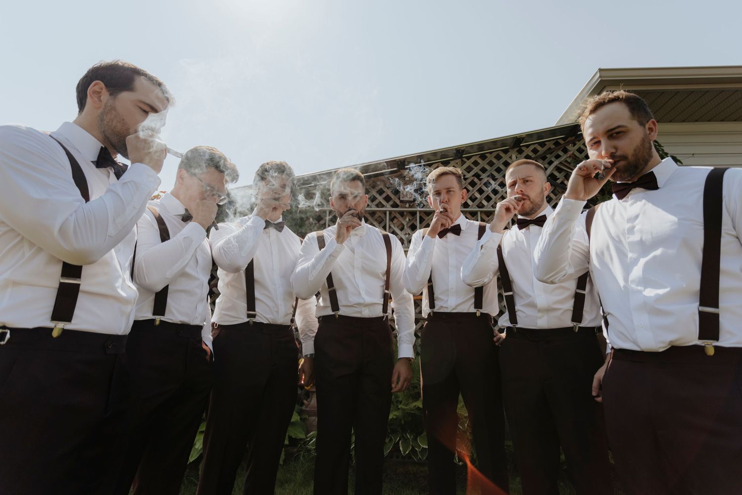 Wedding guests in formal attire dance and celebrate under a white tent during an outdoor reception.