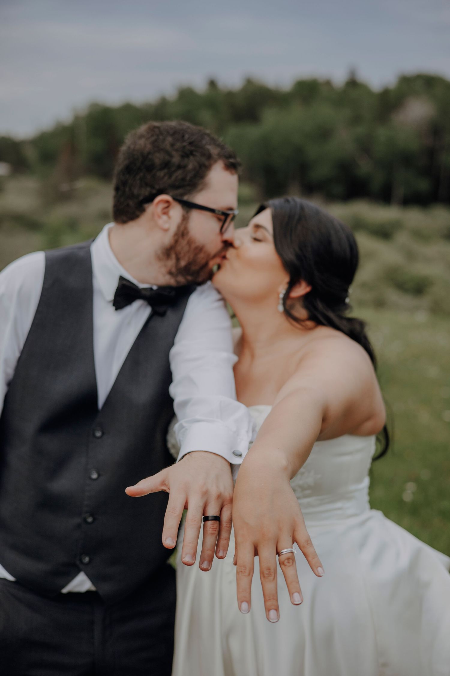 Close-up shots of wedding rings and romantic moments captured during an outdoor wedding celebration.