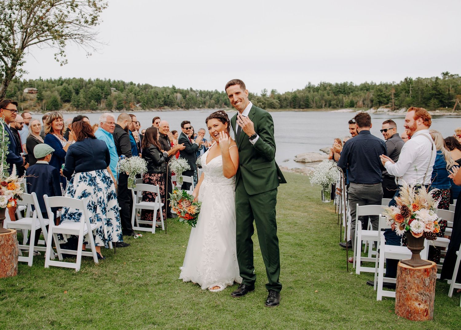 Lakeside wedding ceremony setup with white chairs and floral decorations overlooking the water.