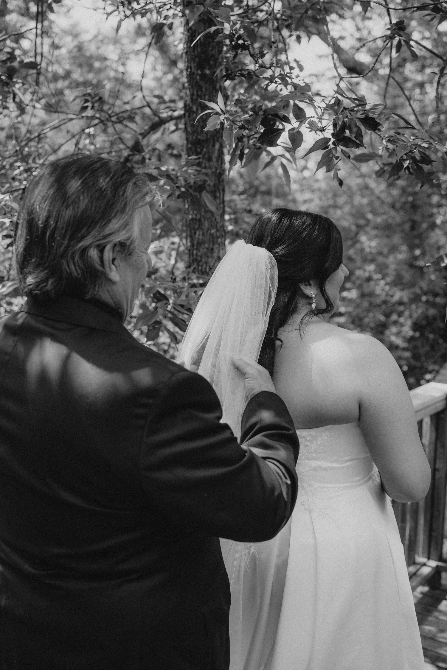 A sequence of black and white photos showing a couple in wedding attire embracing in an outdoor wooded setting.