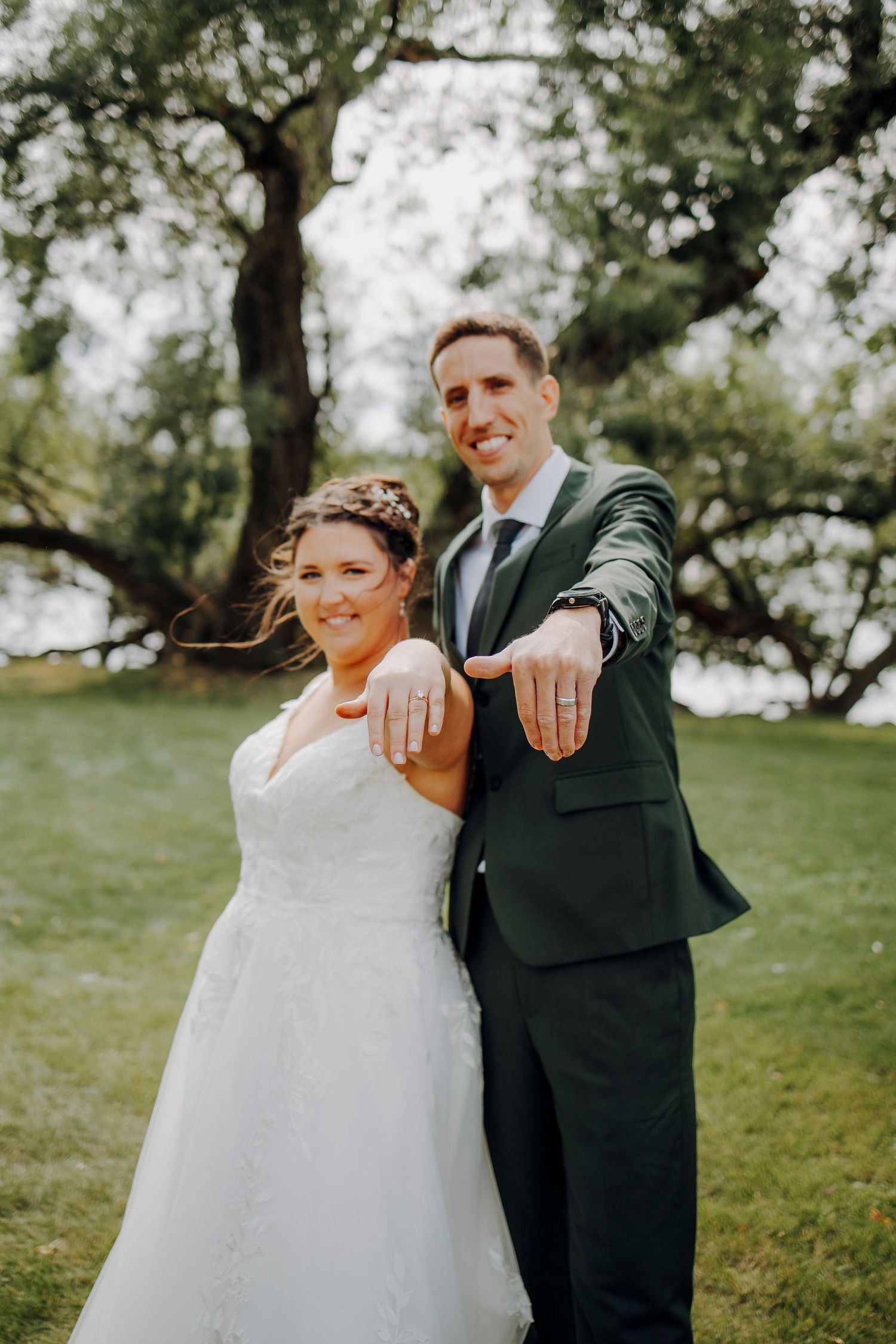 Wedding couple sharing joyful moments in a sunny outdoor garden setting.