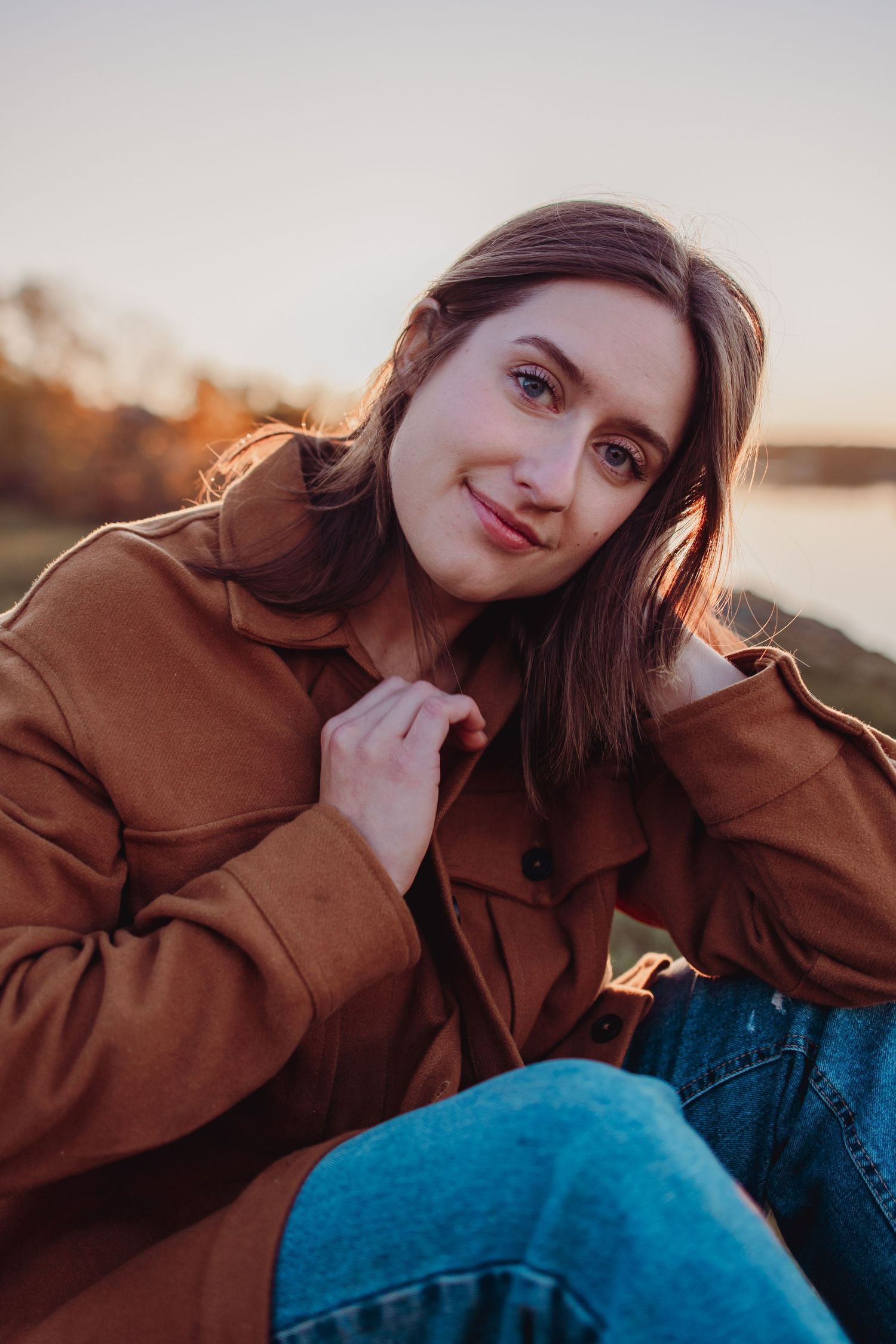 Dreamy sunset portraits of someone in casual wear resting near a waterfront.
