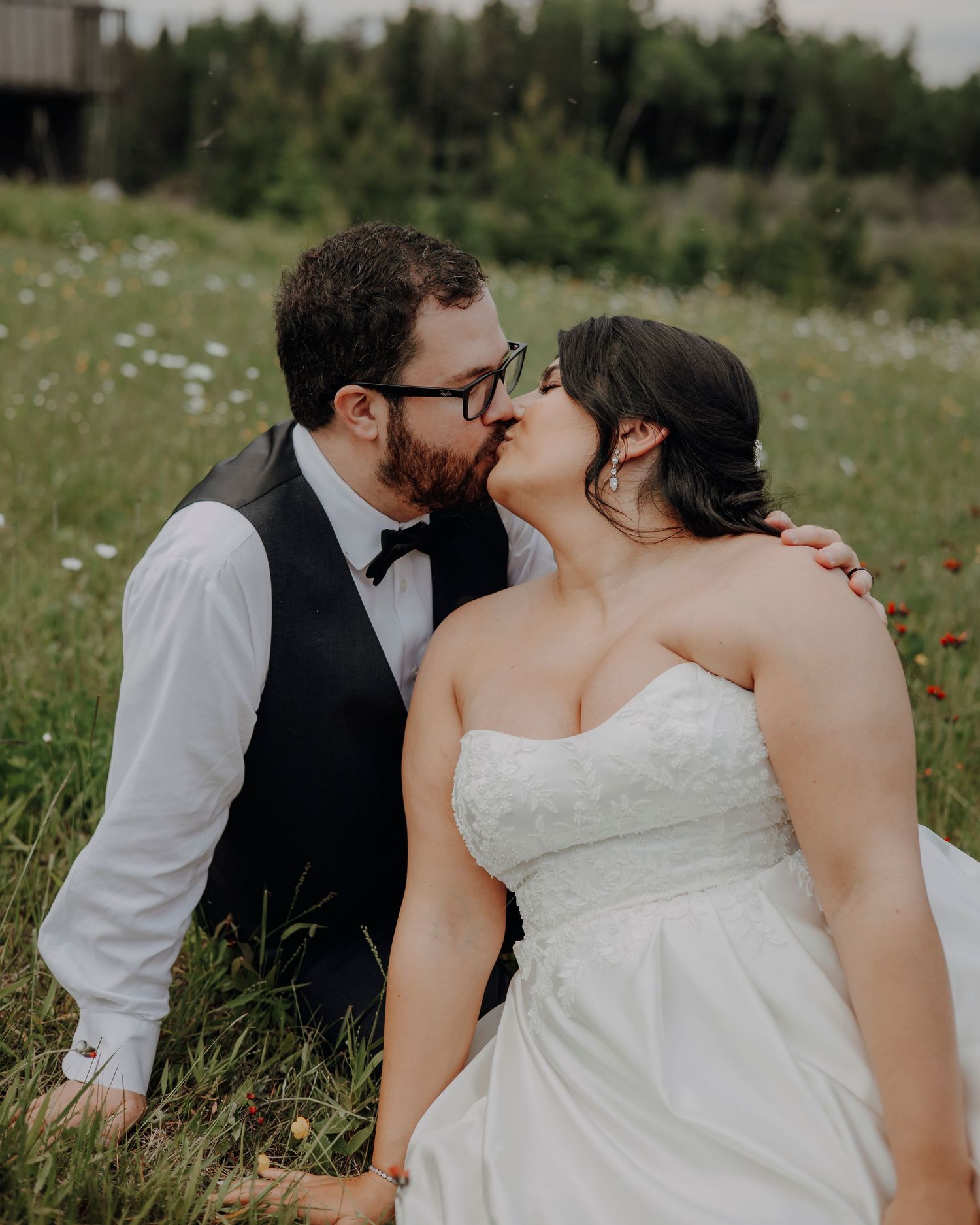 A romantic wedding photo sequence captured in a meadow with wildflowers and natural lighting.