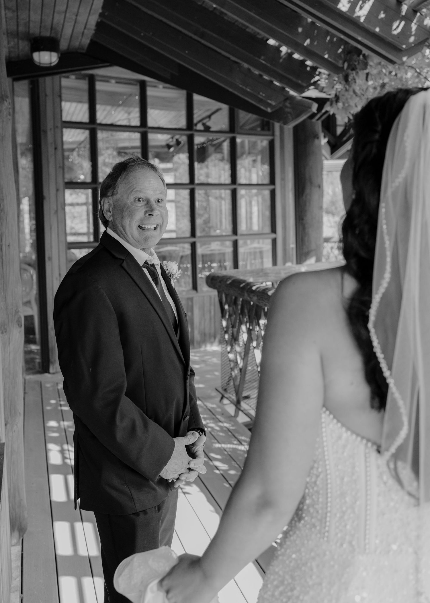 Elegant indoor wedding ceremony venue with white decor and natural lighting.