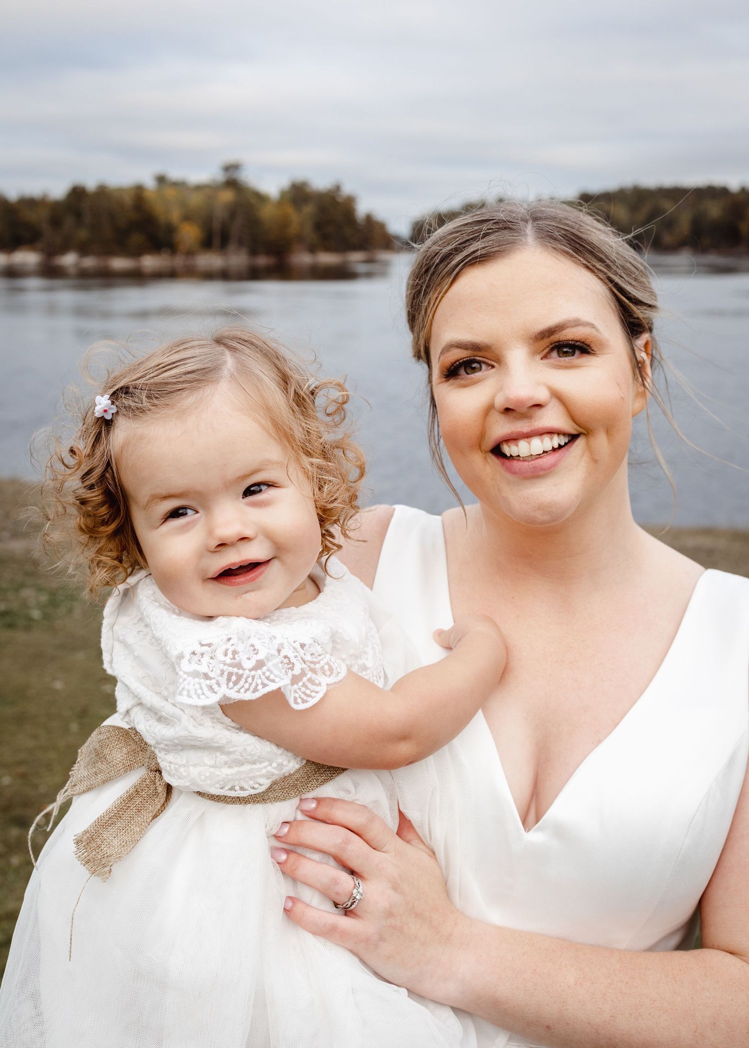 A wedding moment captured by a lake with soft autumn colors in the background.