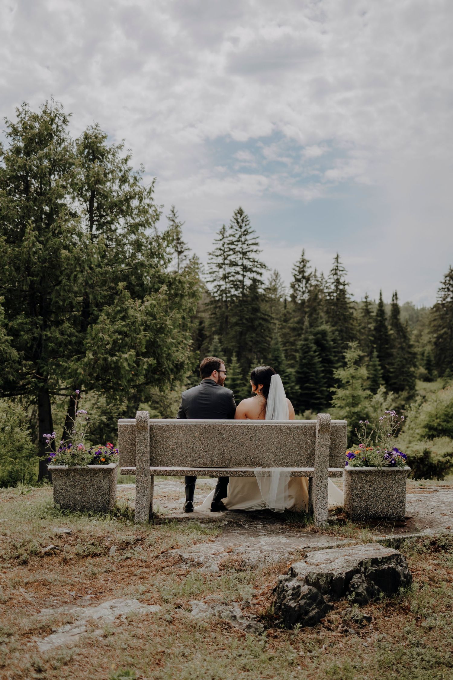 A series of wedding photos featuring a couple sitting on stone benches in a natural outdoor setting.