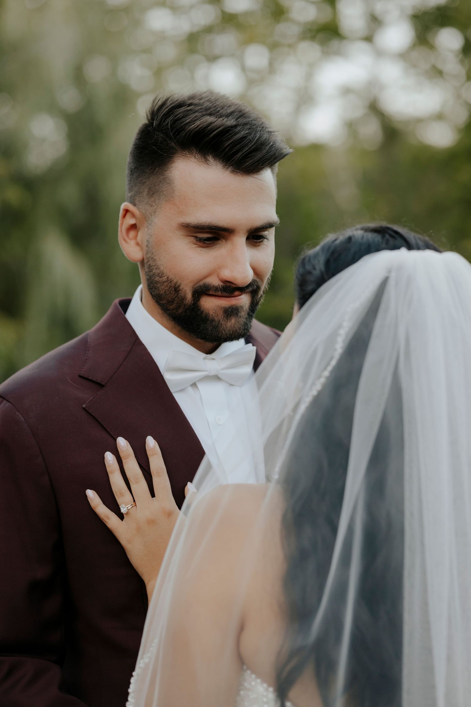 A romantic wedding moment captured as a couple shares an intimate kiss through a delicate white veil.