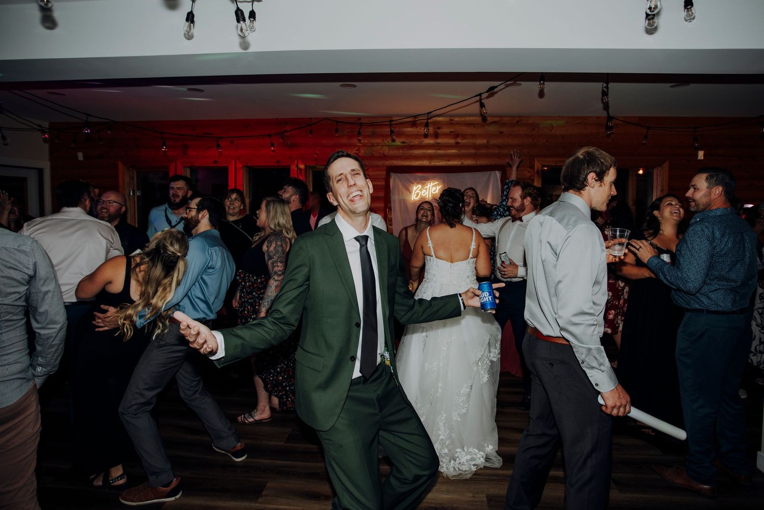 Wedding reception dance floor with couples dancing under dim lighting.