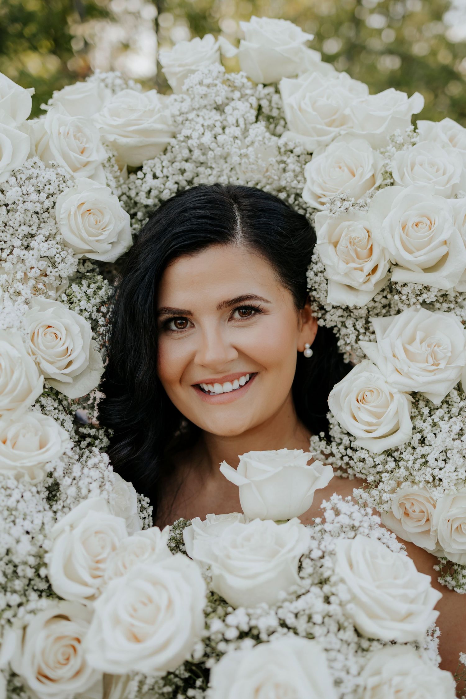 A beautiful arrangement of white roses and baby's breath flowers in a bridal portrait.