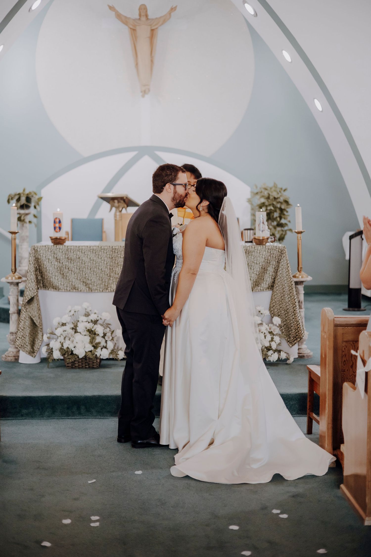 Wedding ceremony sequence inside a church with arched ceilings and decorative floral arrangements.