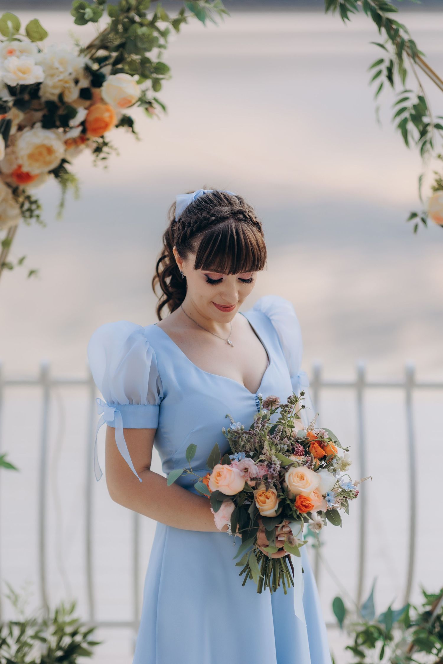 Portret de mireasă la cununia civilă, purtând o rochie albastră elegantă și ținând un buchet de trandafiri, cadru realizat în aer liber