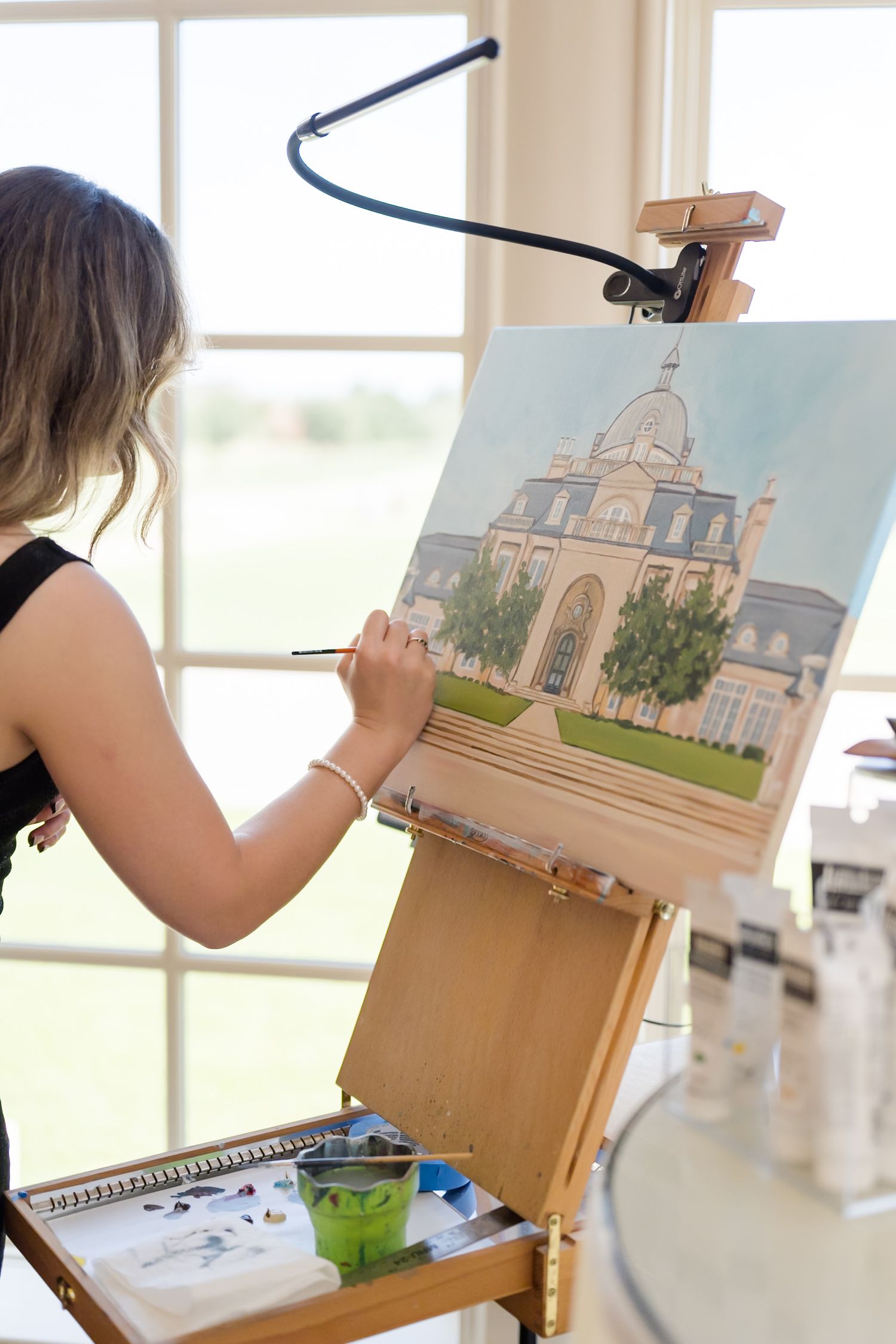 Artist working on detailed architectural illustrations at wooden easel. Live wedding portraits, photography DFW weddings