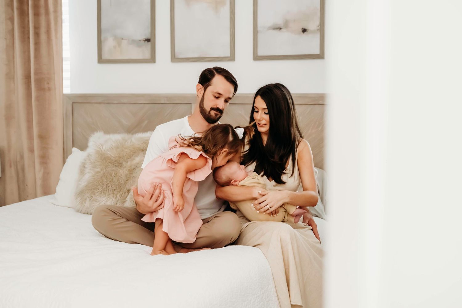 Family spending quality time together on bed in softly lit bedroom.