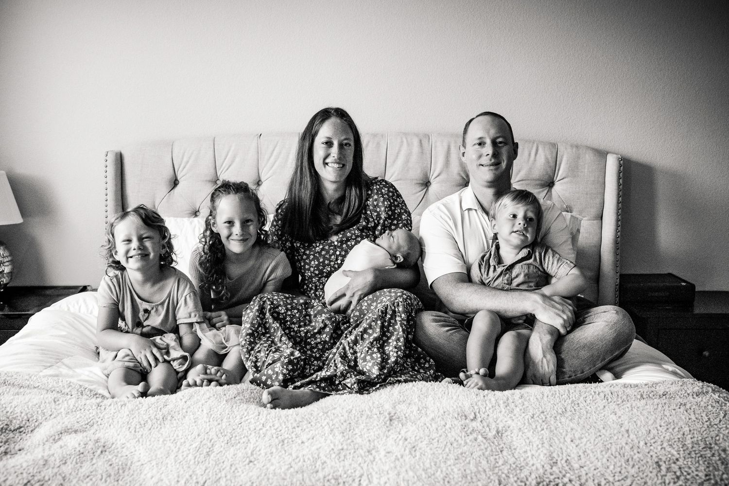 A series of black and white photographs showing people lying together on a white bed.
