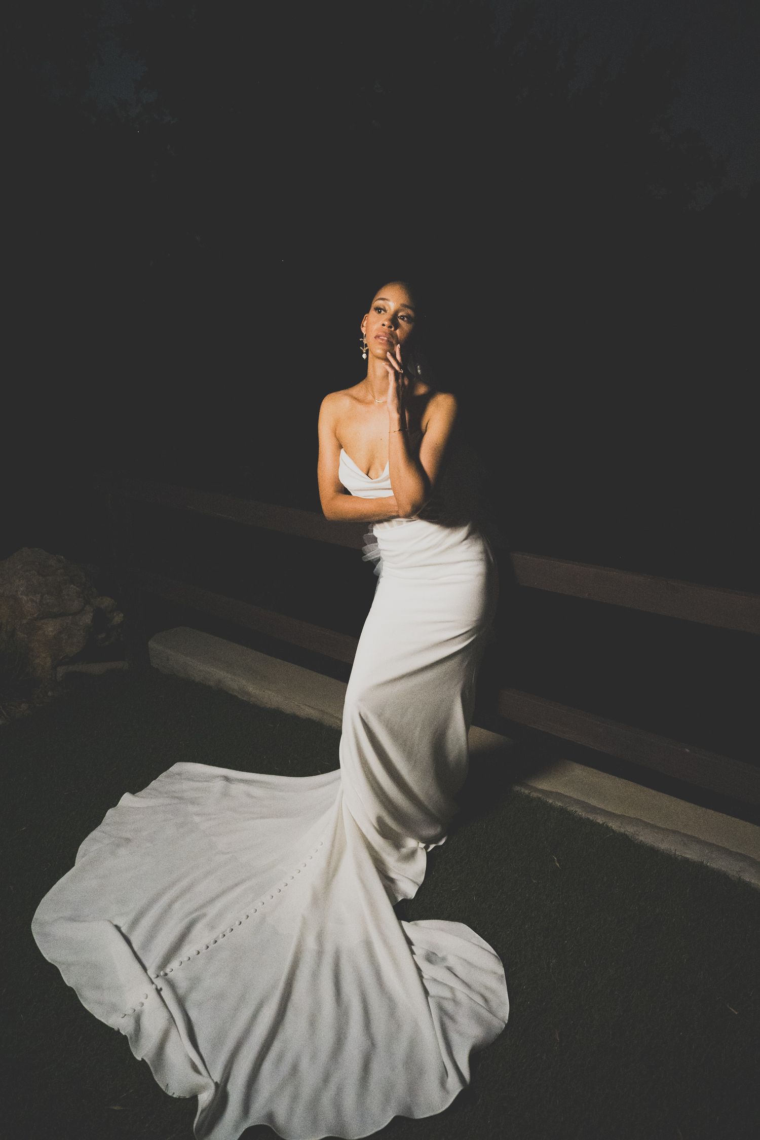 A dancer in a flowing white dress spins gracefully against a dark background creating elegant movement.