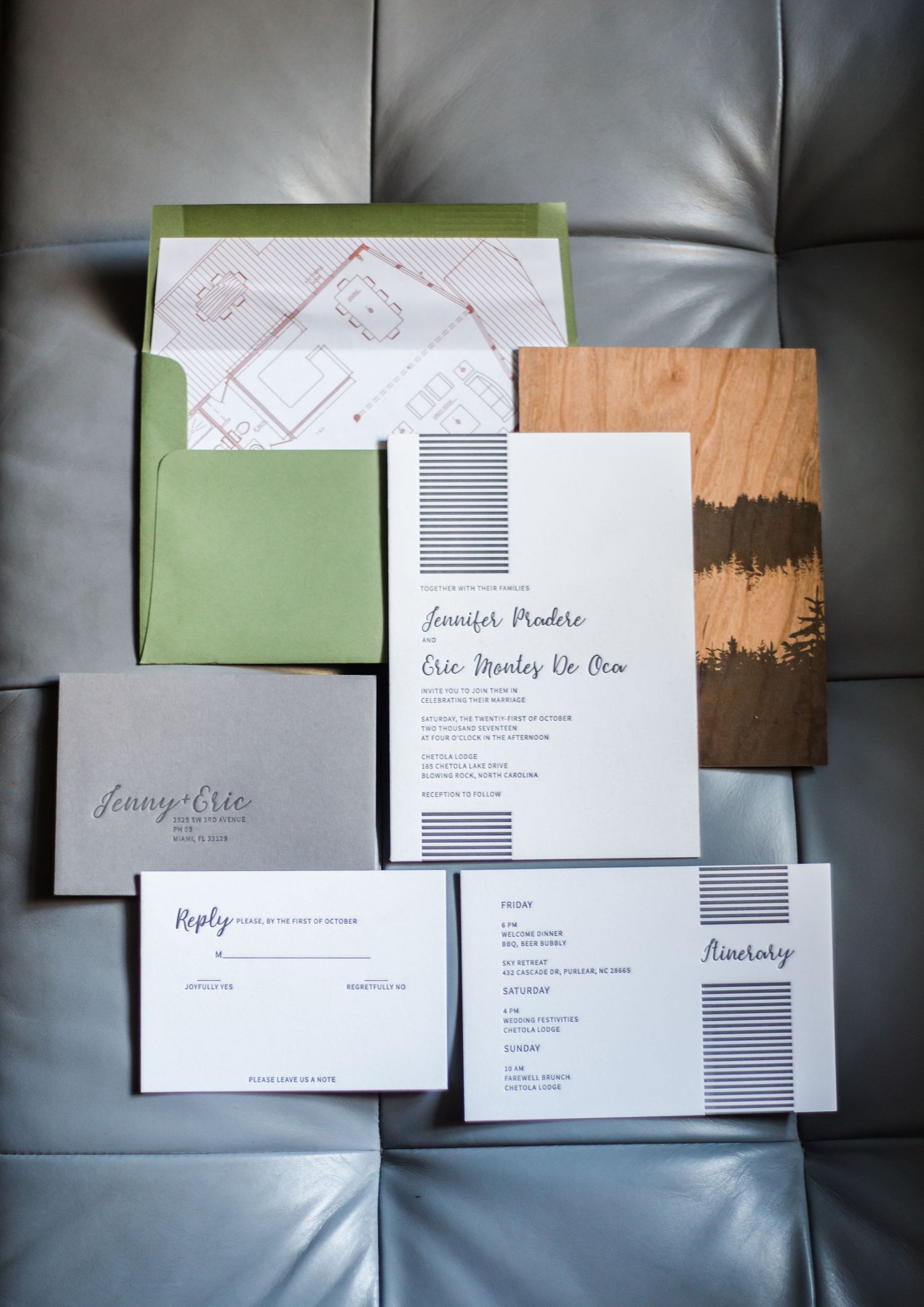 Modern wedding invitation suite with sage green envelope and minimalist black and white design on leather background.