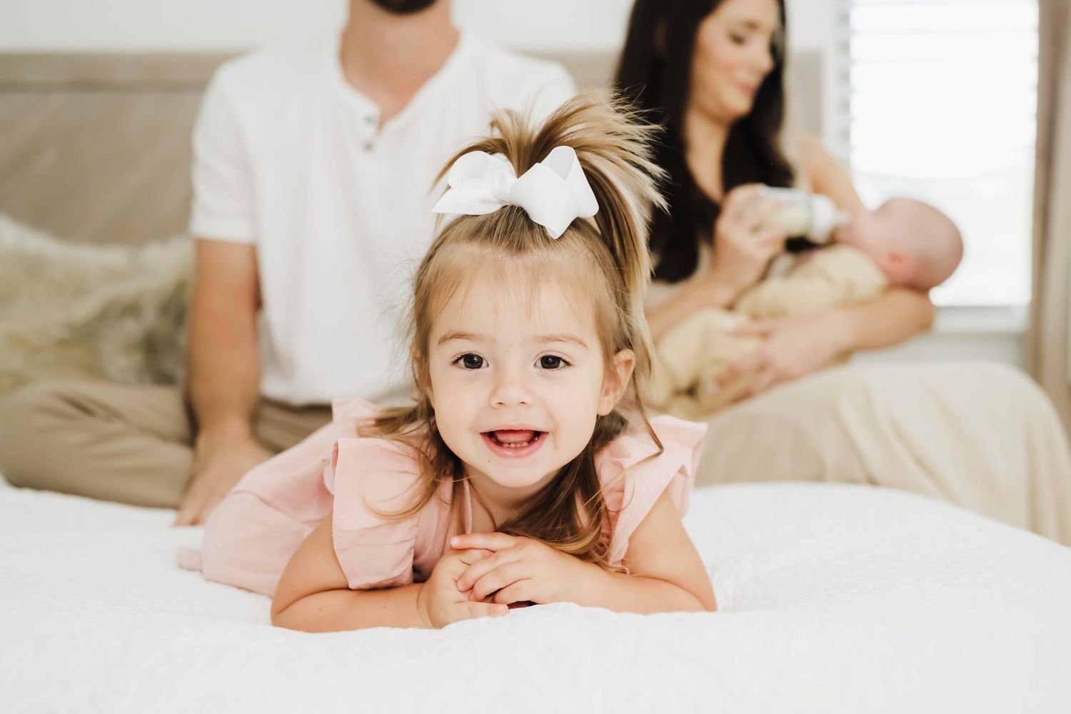Intimate family lifestyle photoshoot showing tender moments on a bed.