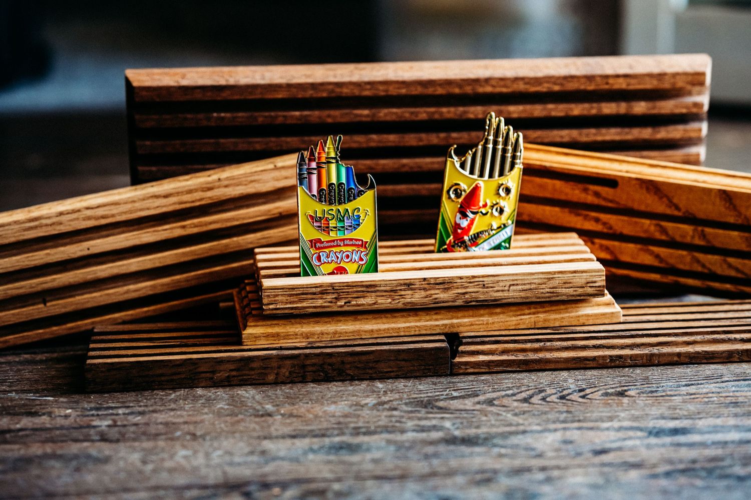 Wooden planks stacked in a row with colorful children's crayons placed between them on a rustic surface.
