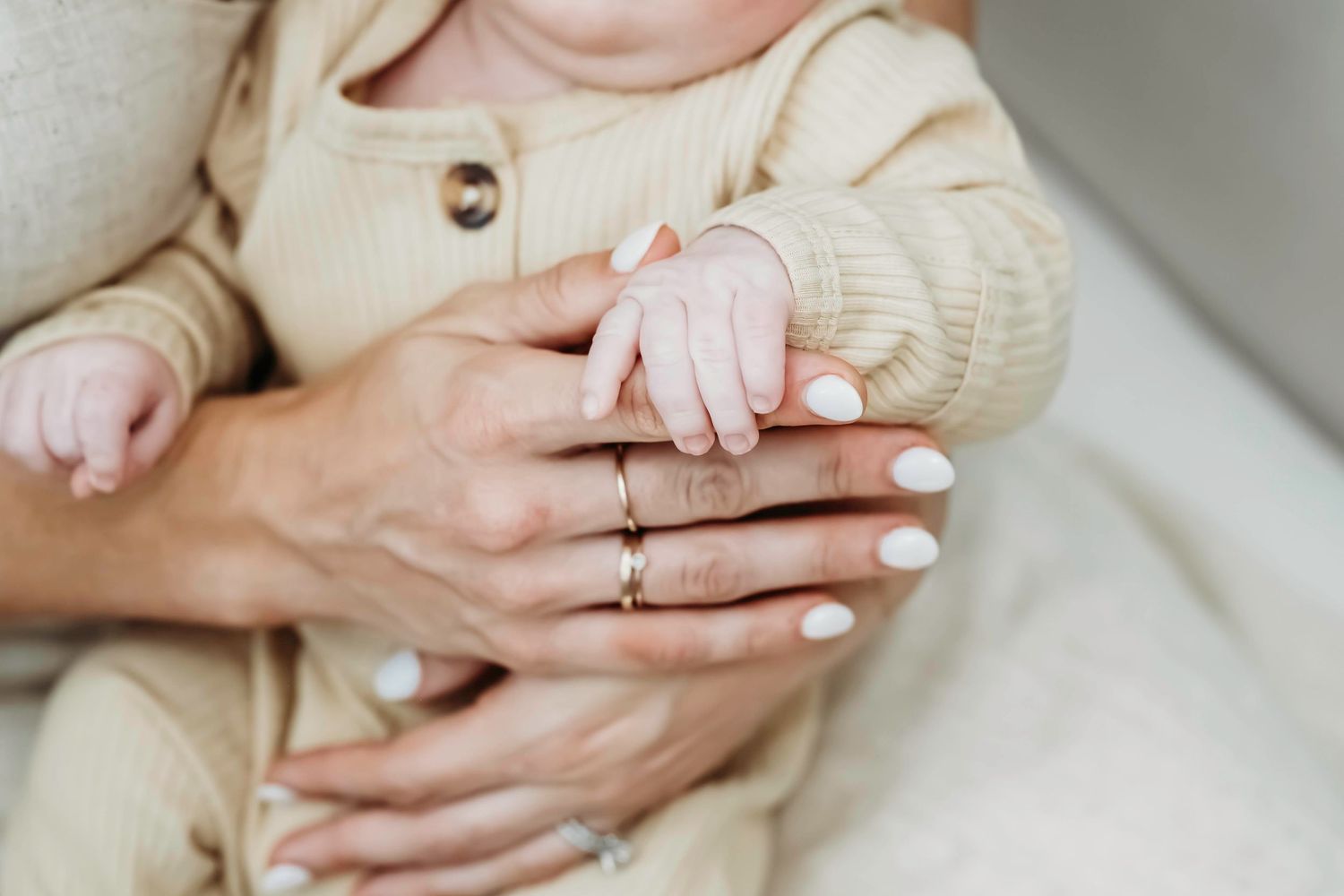 Close-up shot of parent holding baby's tiny hand showing delicate details and connection.
