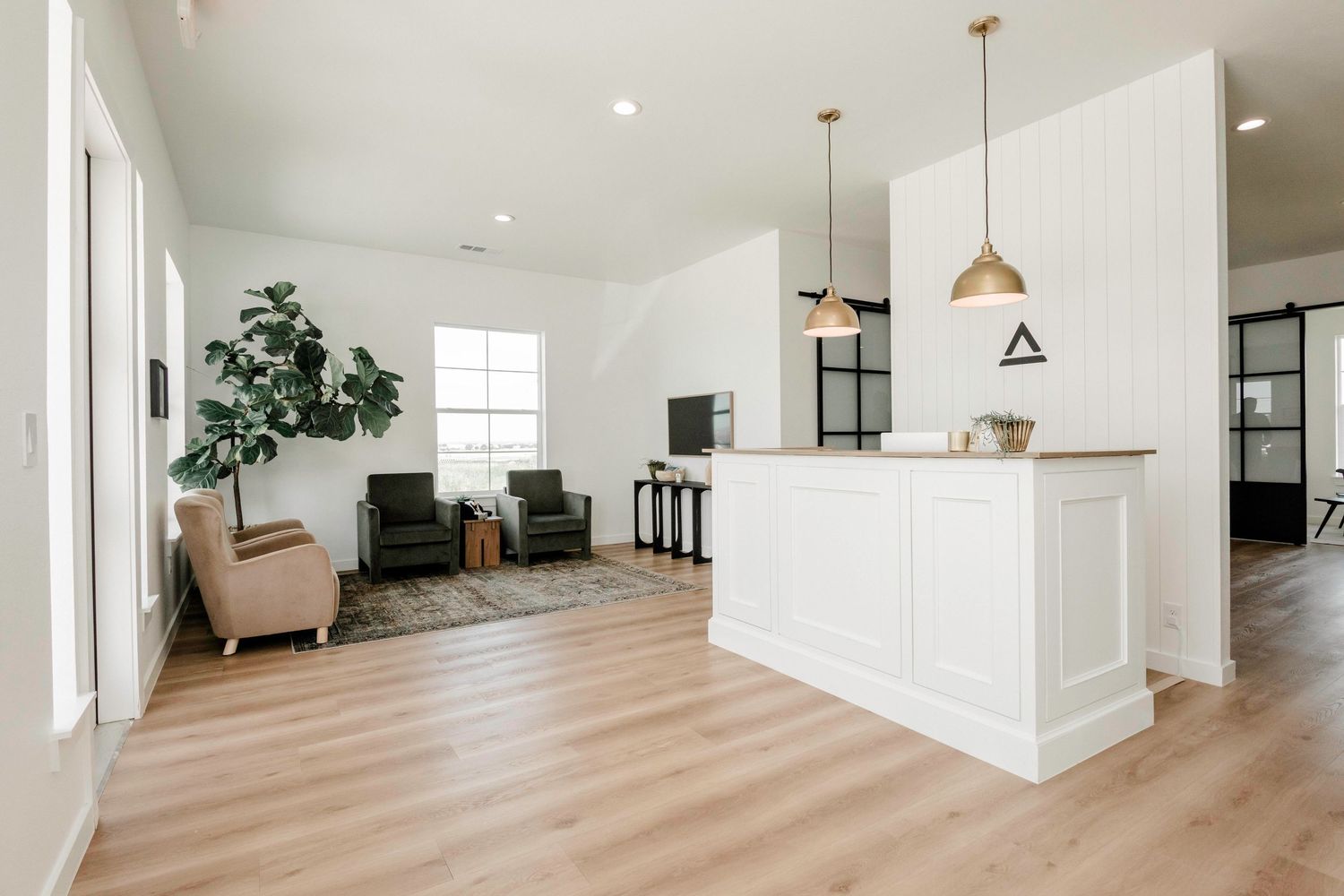 Spacious white interior with wood flooring and natural lighting.
