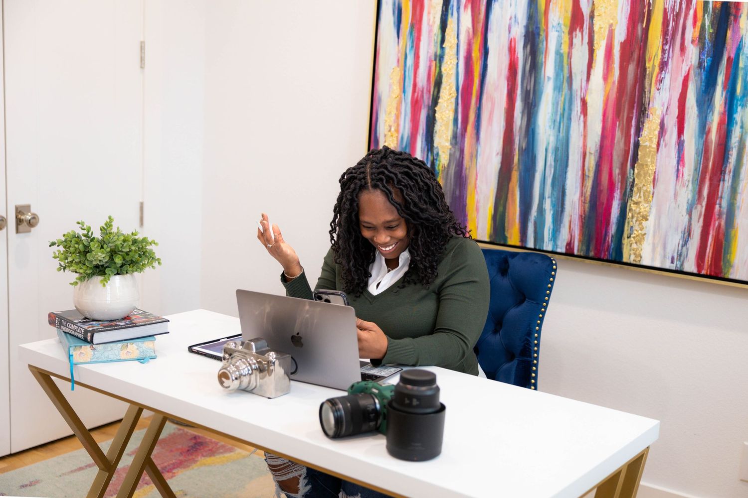 A colorful office workspace with modern furnishings, vibrant striped wall art, and plants creating an energetic atmosphere.