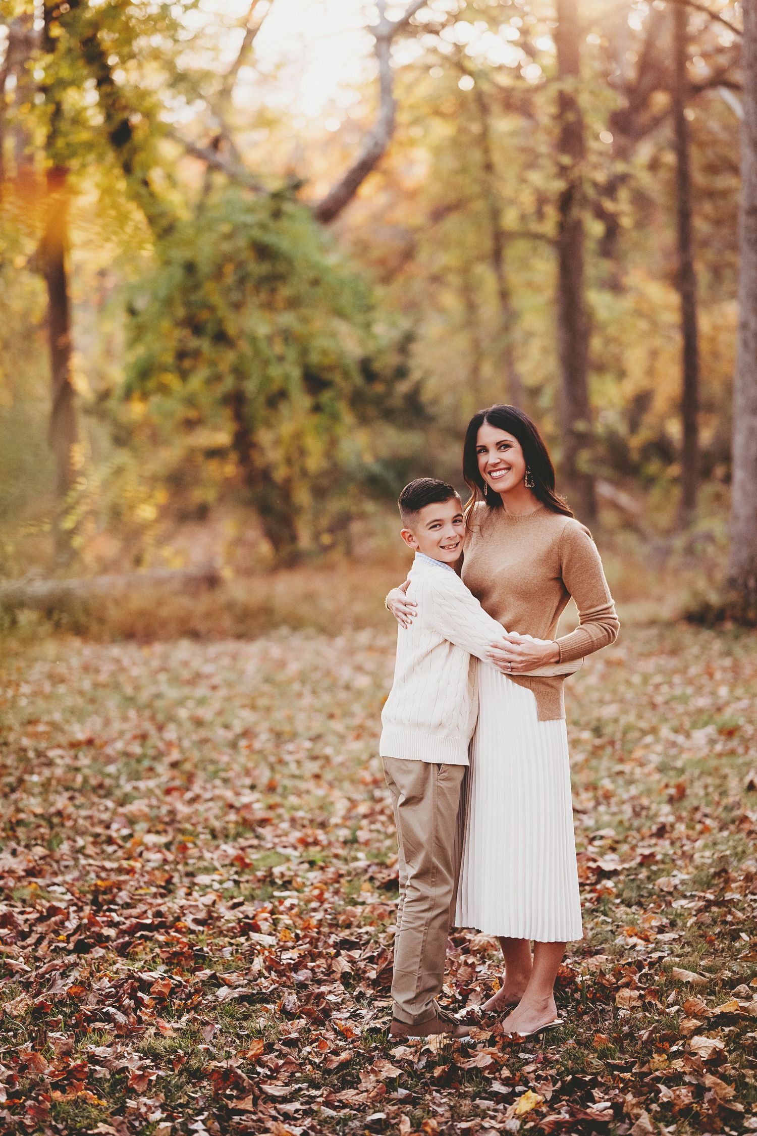 Fall foliage creates a warm backdrop for an outdoor photoshoot in the woods.
