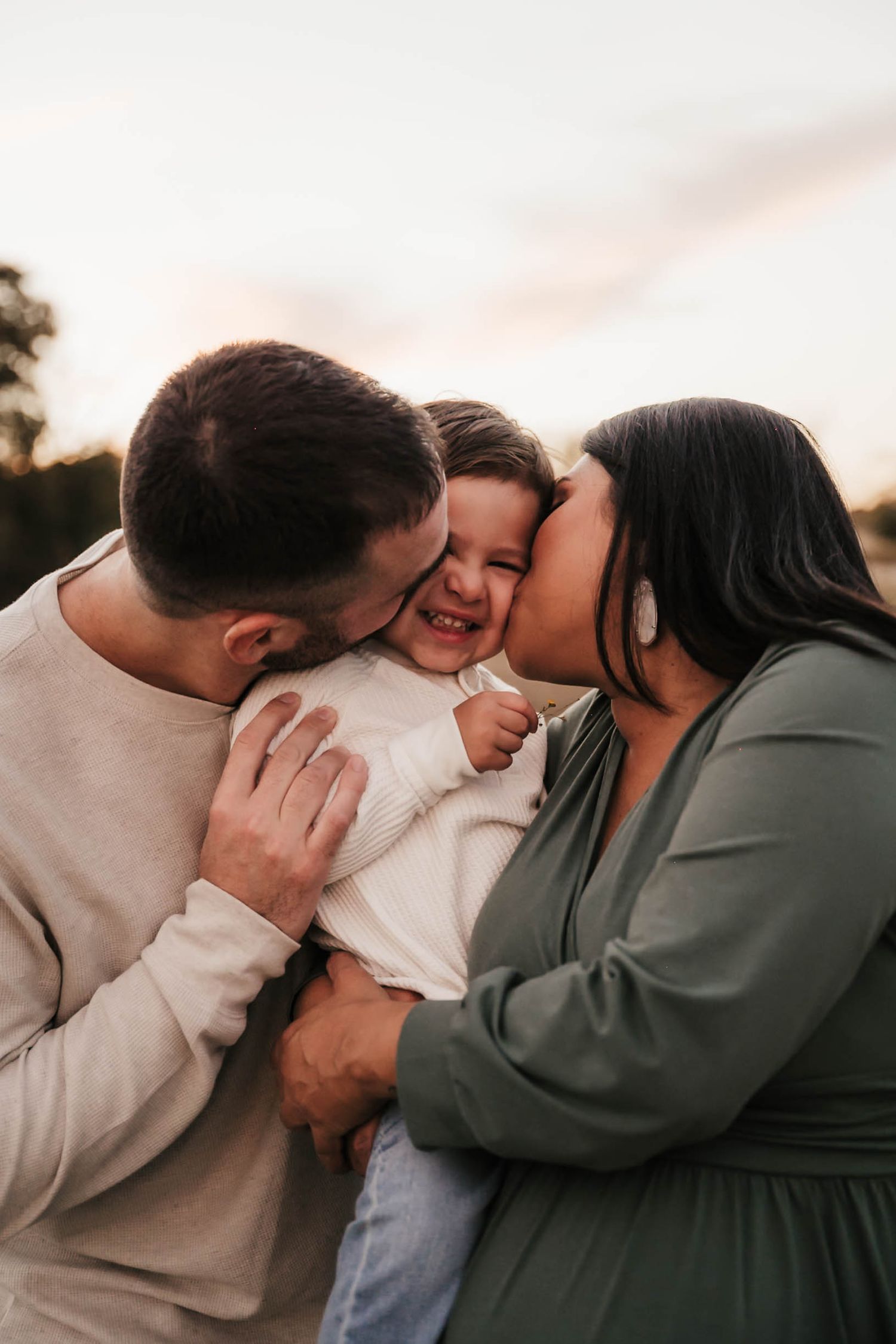 A couple shares intimate moments in a series of candid romantic photos wearing casual grey and olive clothing.