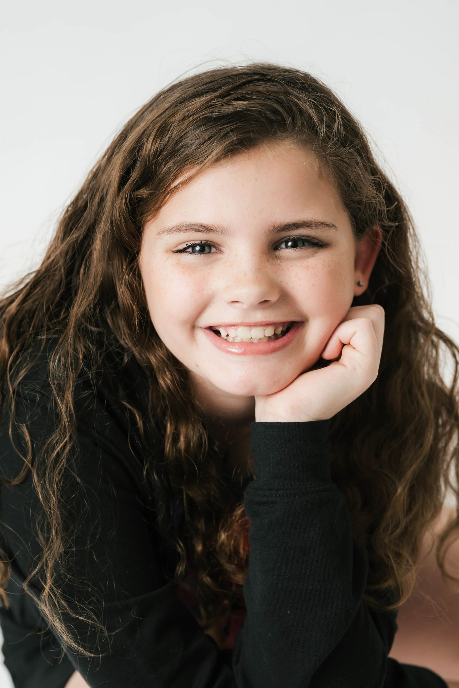 A series of expressive portrait shots showing joyful smiles and playful poses against a light background. Portraits by Knot & wing Photo