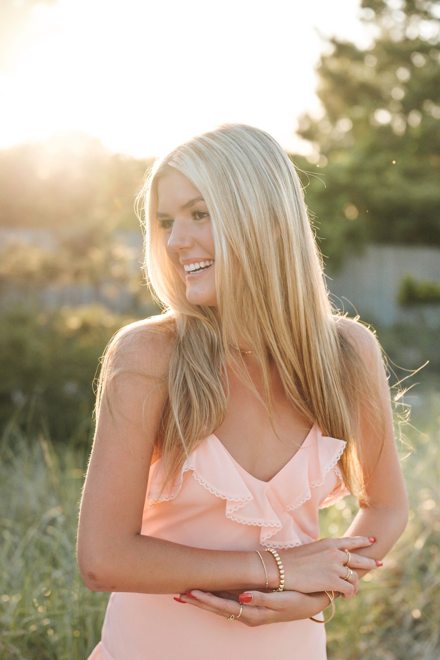 Golden hour photoshoot in a peachy pink dress with natural sunlight creating a warm, dreamy atmosphere.