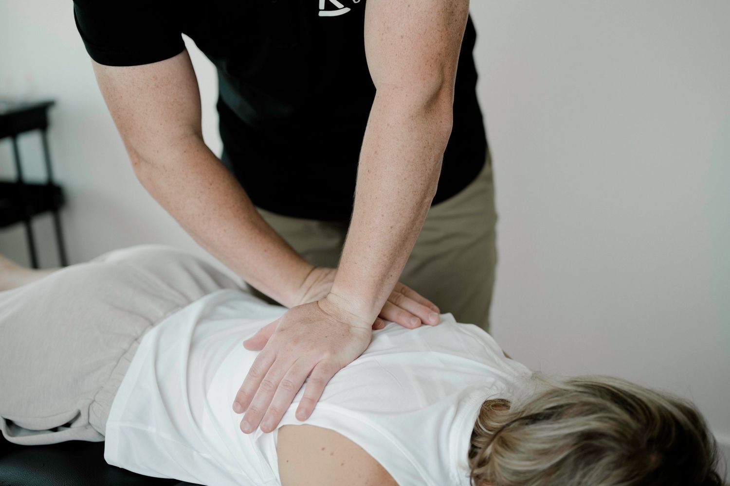 Professional chiropractor providing therapeutic treatment on massage table.