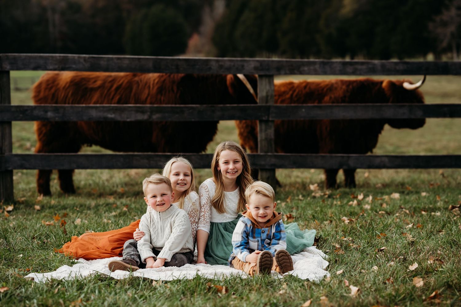 Family enjoying relaxed moments on blanket during outdoor fall photography session.