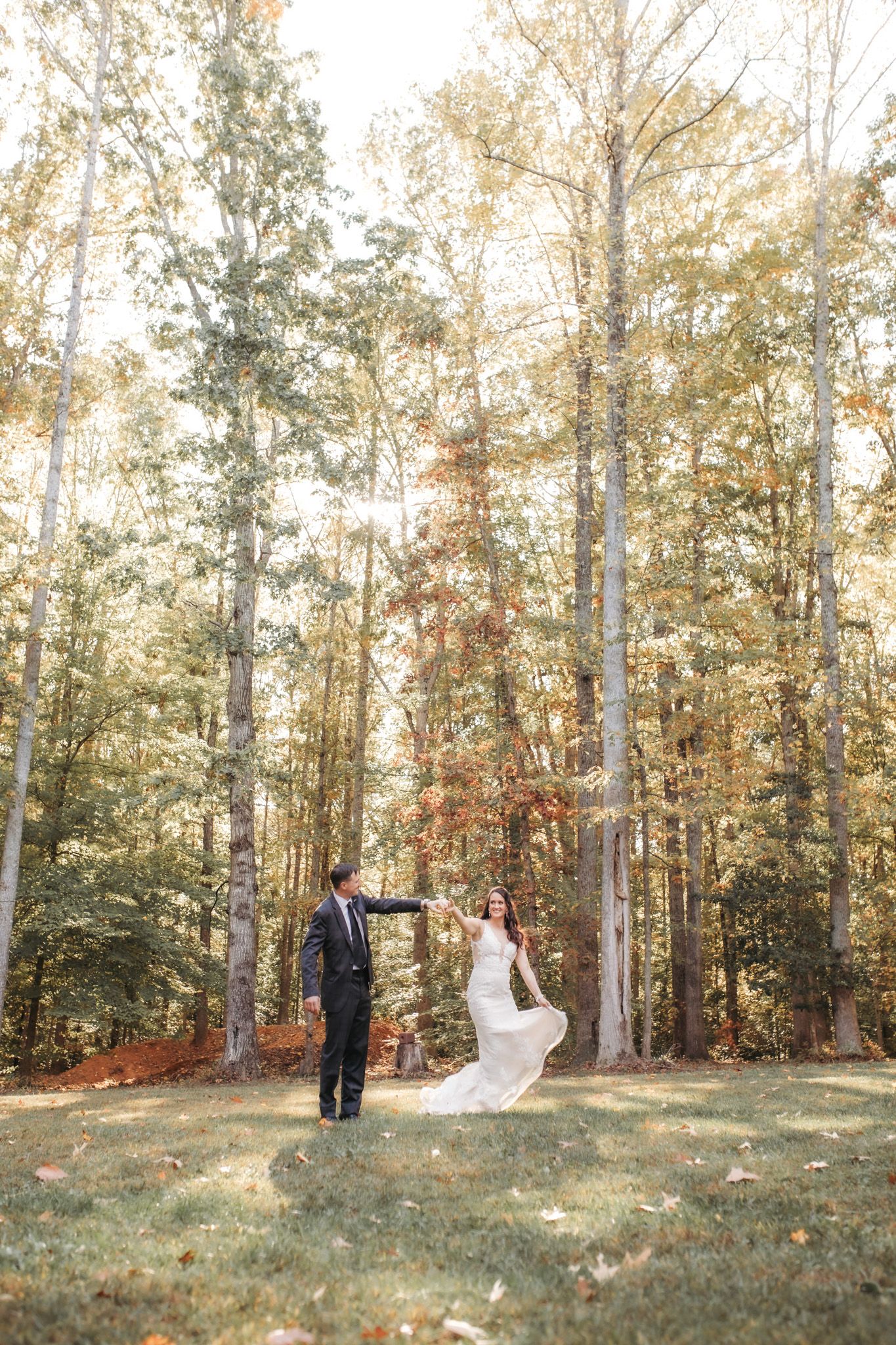 Wedding couple photographed in a scenic autumn forest clearing.