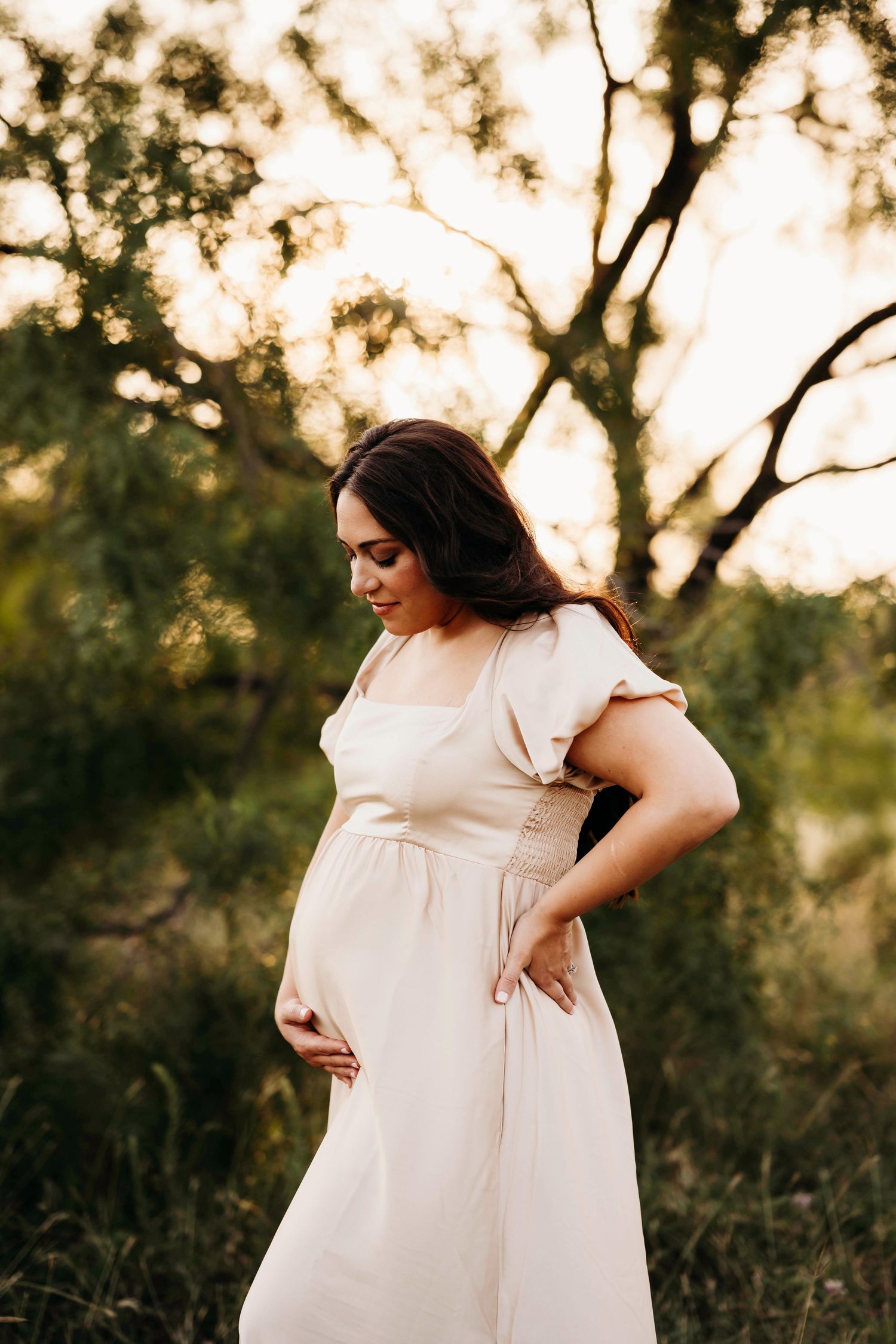 Gentle maternity portraits captured at golden hour in a white flutter sleeve dress.
