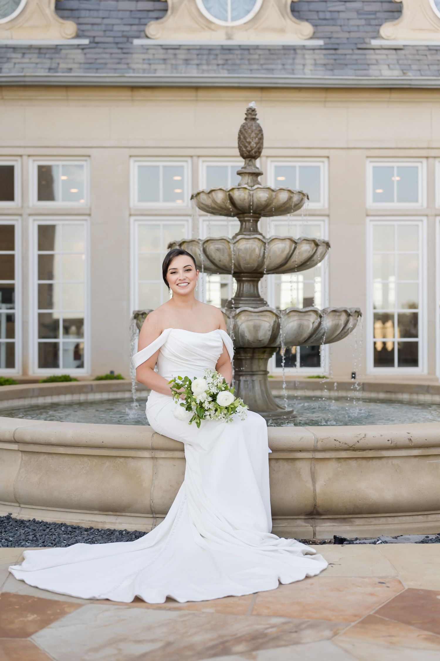 Elegant bridal portraits featuring a white wedding dress against a classical stone fountain backdrop.