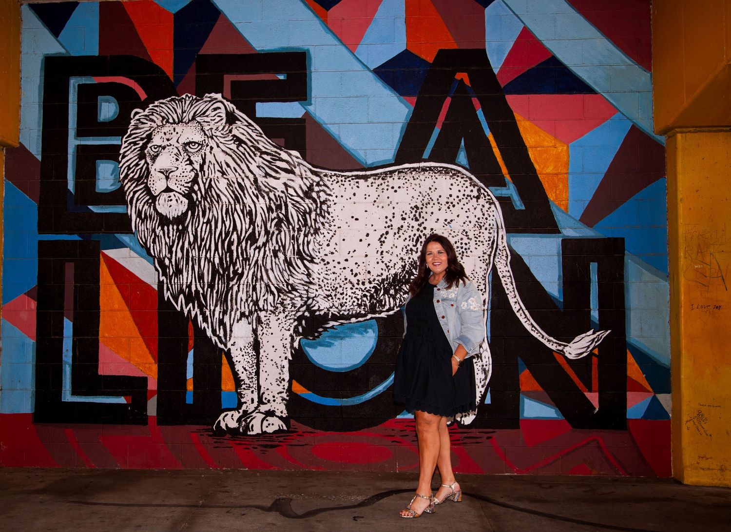 Woman celebrating her birthday with a creative portrait session by a colorful mural in downtown Joplin, Missouri.