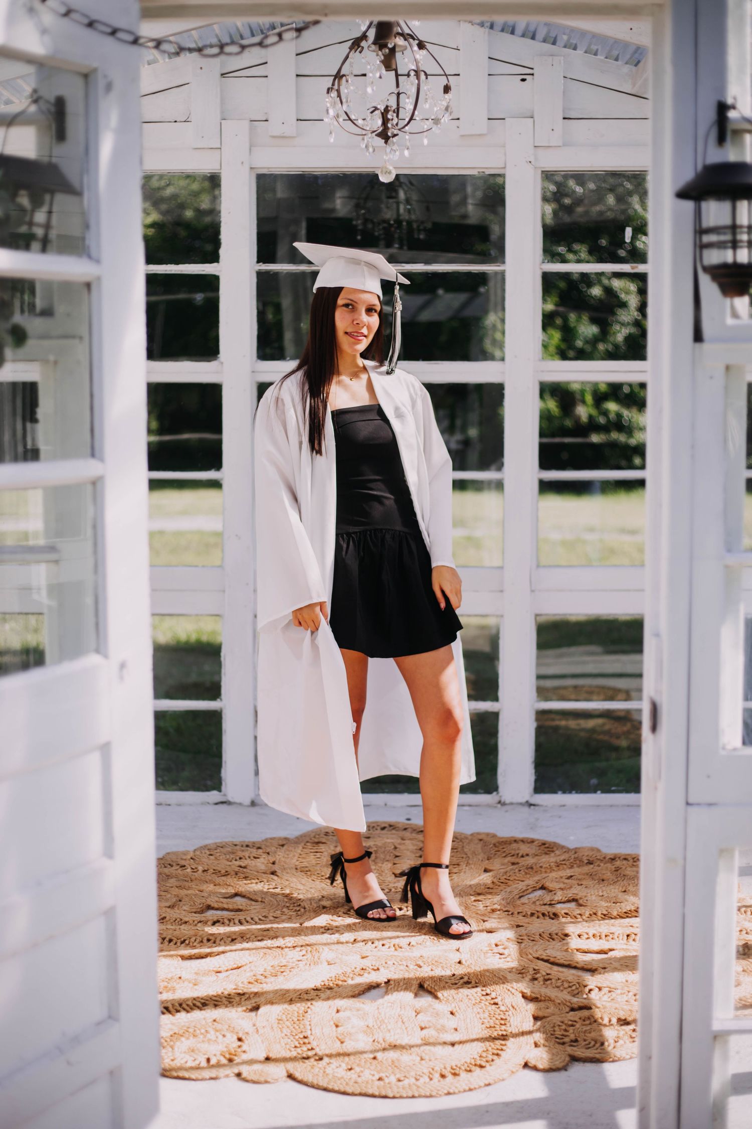 High School senior wearing a white graduation cap and gown during a portrait session in Joplin, Missouri.