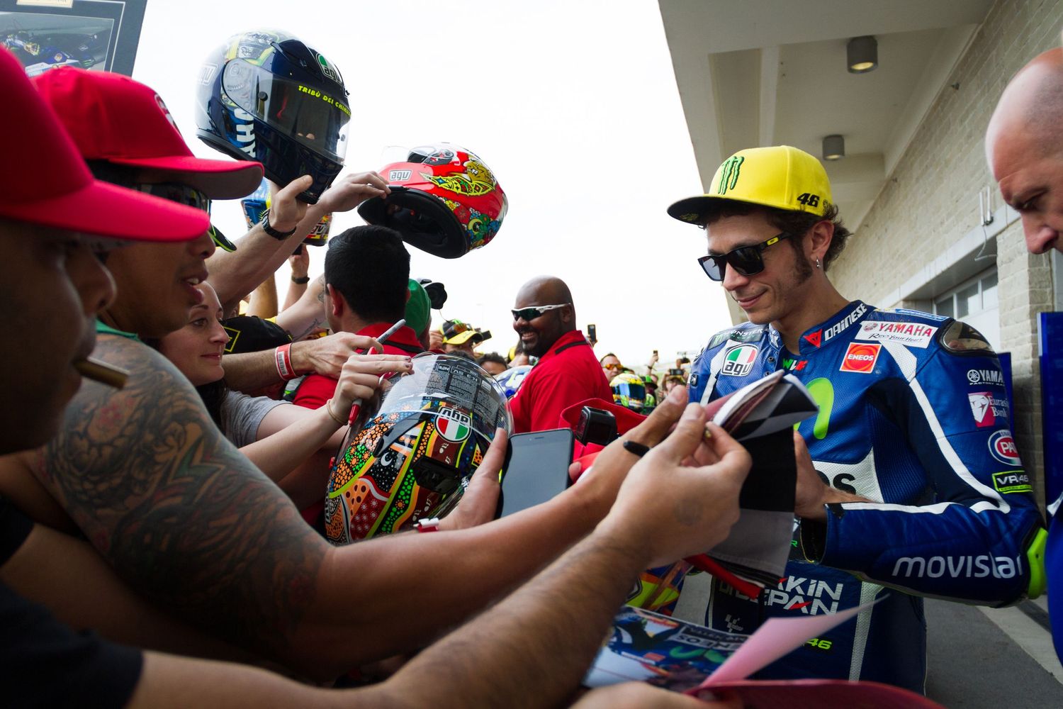 Racing fans gather at a motorsports event to get autographs and memorabilia signed by Valentino Rossi