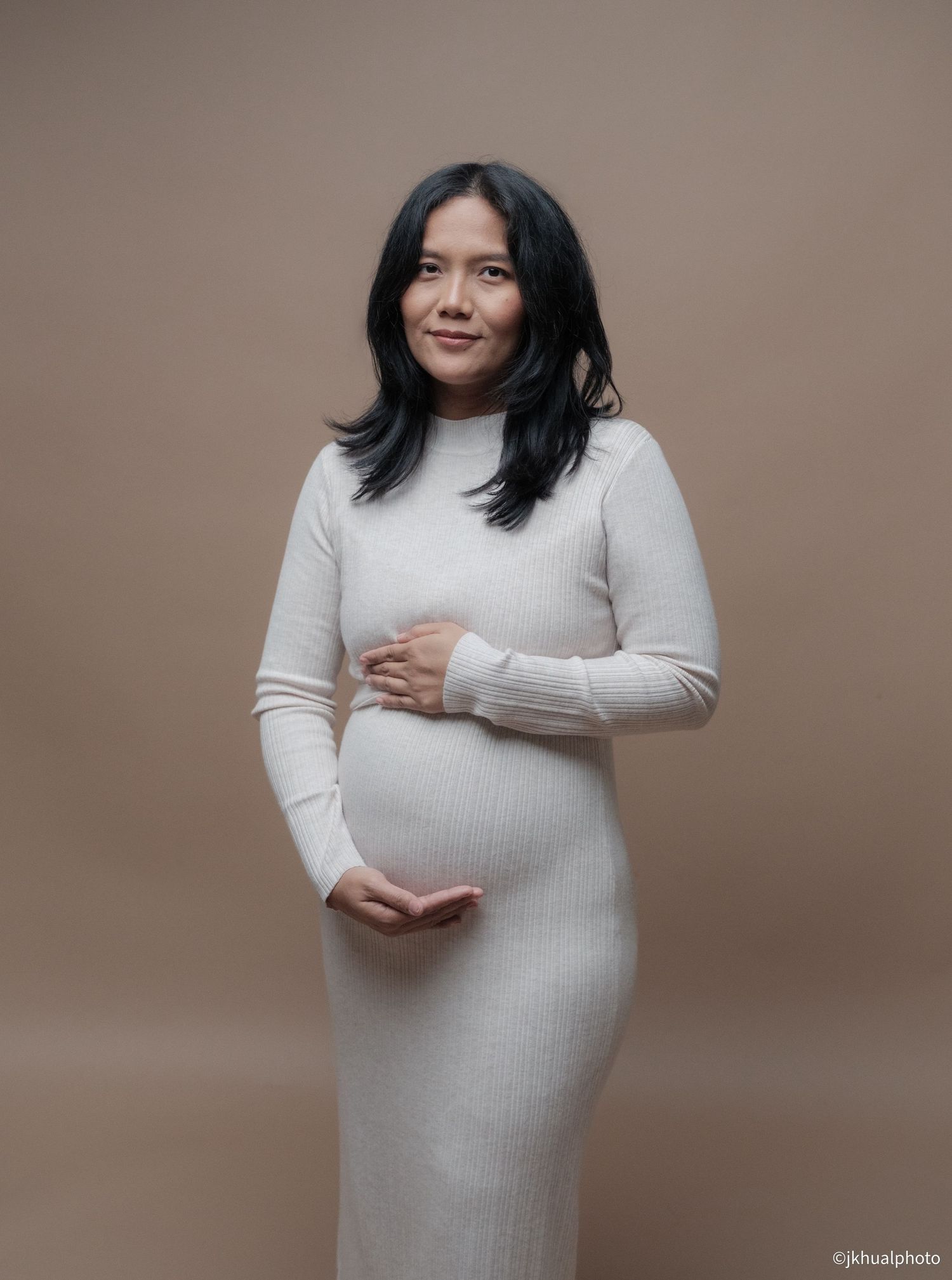 A series of pregnancy portraits showing a woman in a white sweater dress against a beige background.