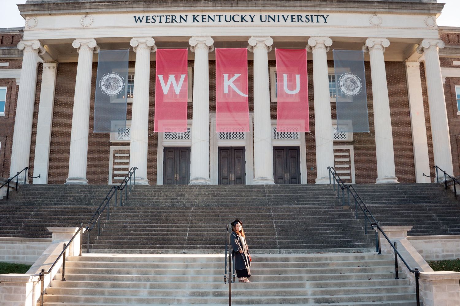 Wide view of Western Kentucky University's columned entrance with red banners.