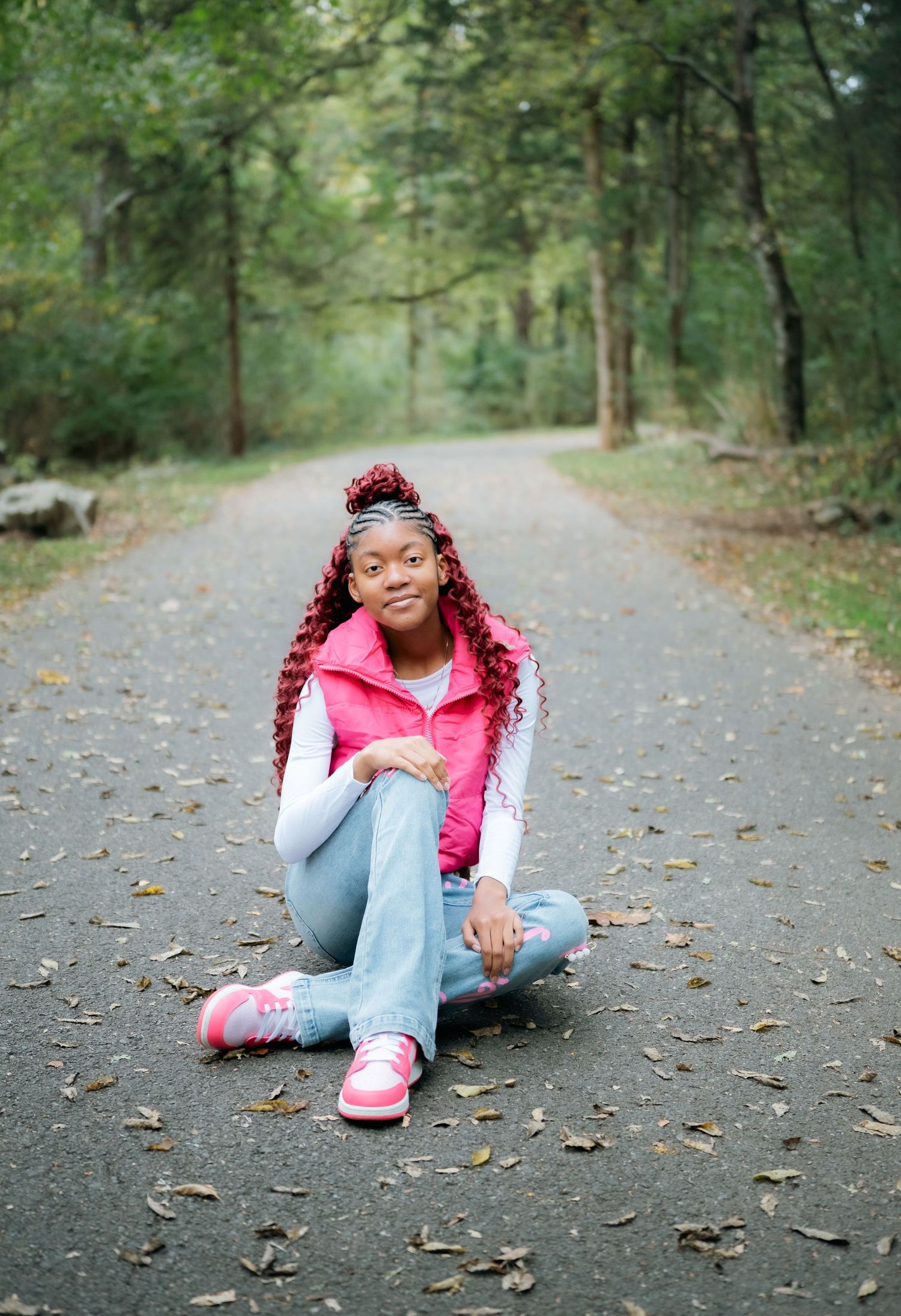 Casual outdoor photo session on a leaf-covered forest path.