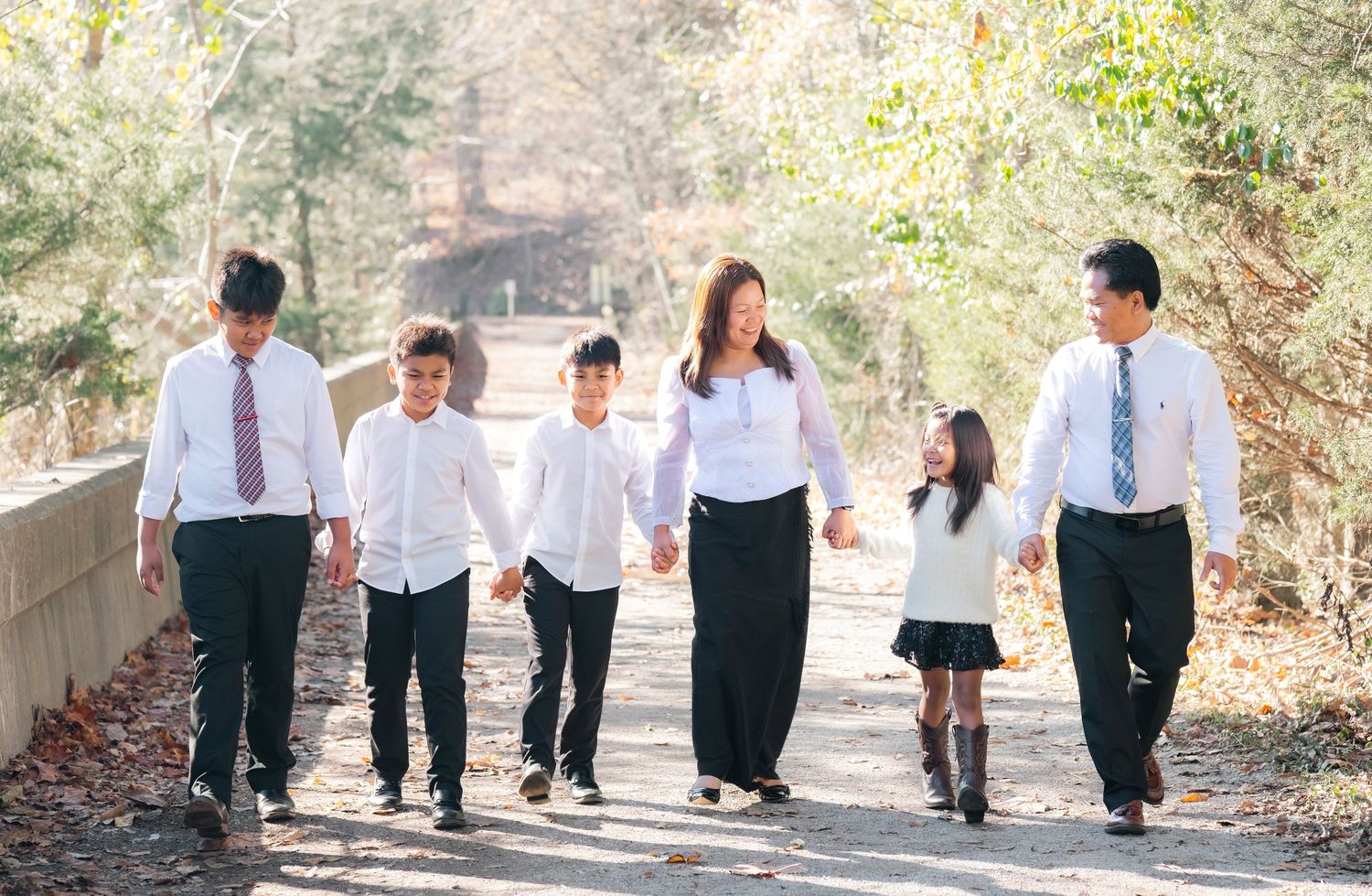 A group walking together on a nature trail wearing matching formal attire.